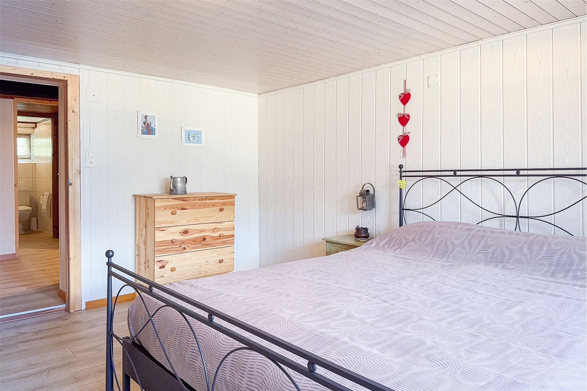 Gemütliches Schlafzimmer mit hellem Holz und Metallbett