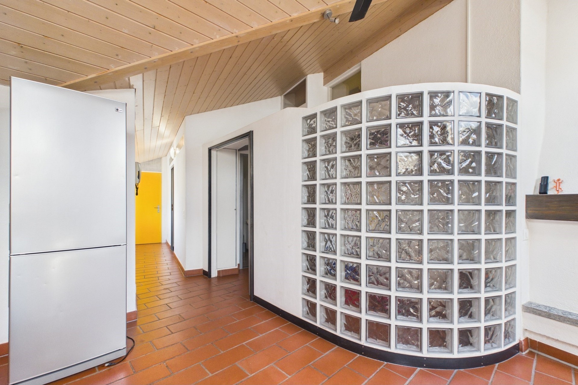 Heller Flur mit Glasbausteinwand und Holzdecke