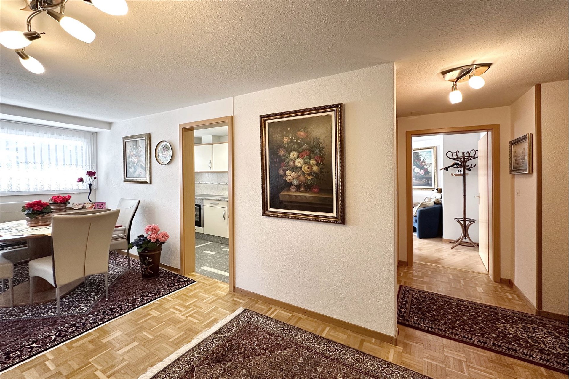 Heller Wohnungsflur mit angrenzendem Essbereich und Durchgängen zur Küche und zum Wohnzimmer