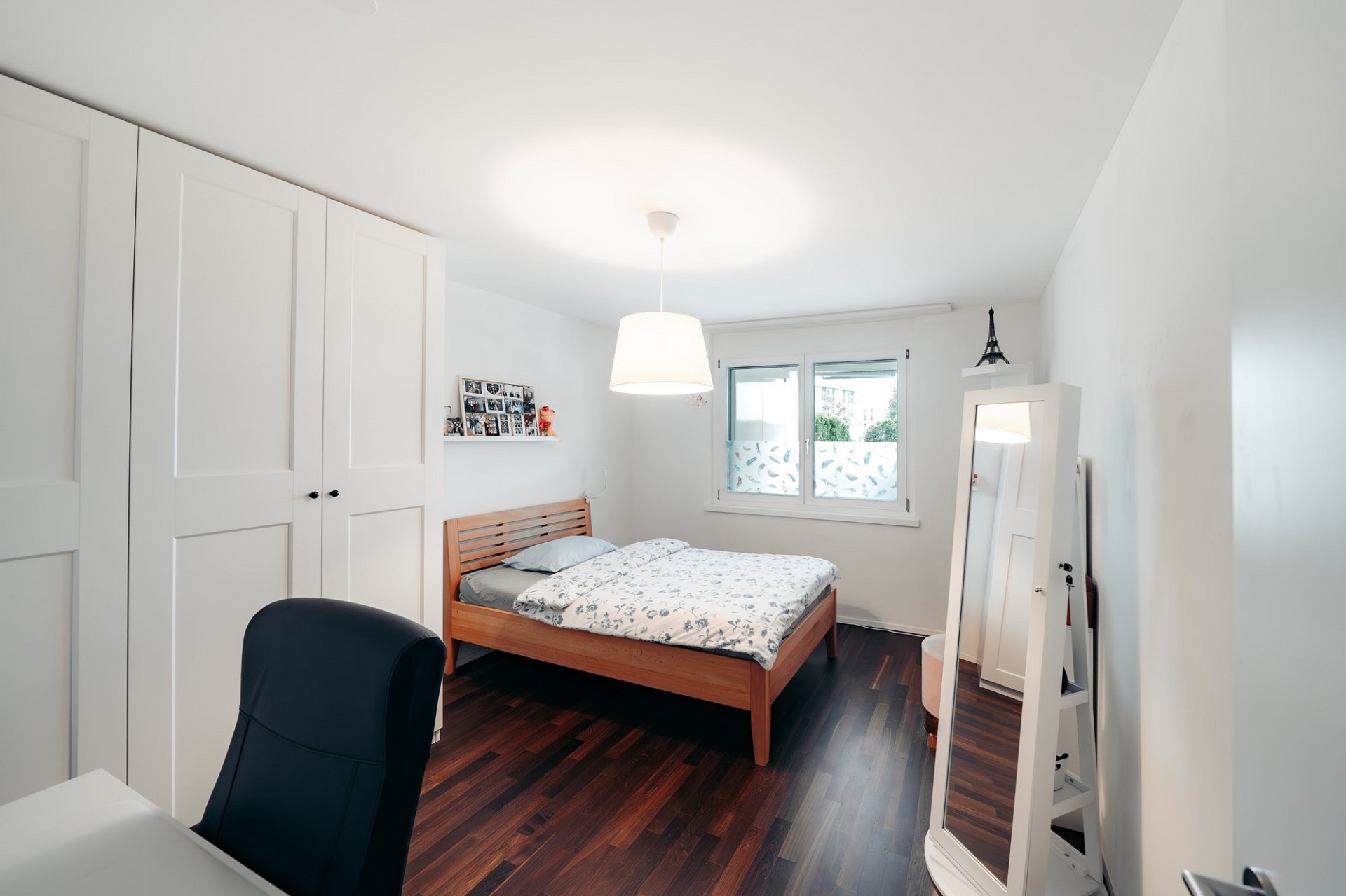 Helles Schlafzimmer mit dunklem Holzboden