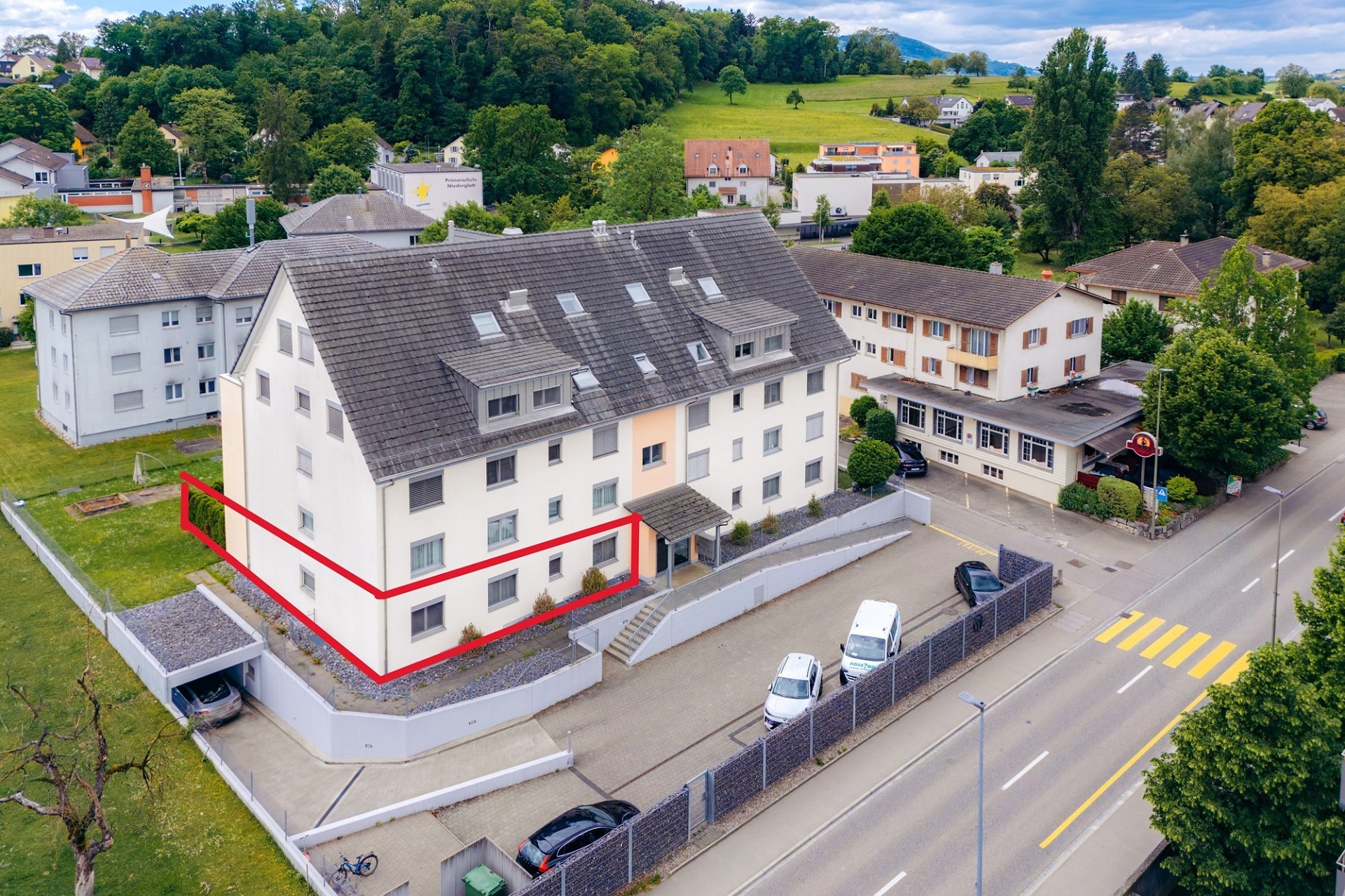 Luftaufnahme eines Mehrfamilienhauses mit markierter Wohneinheit
