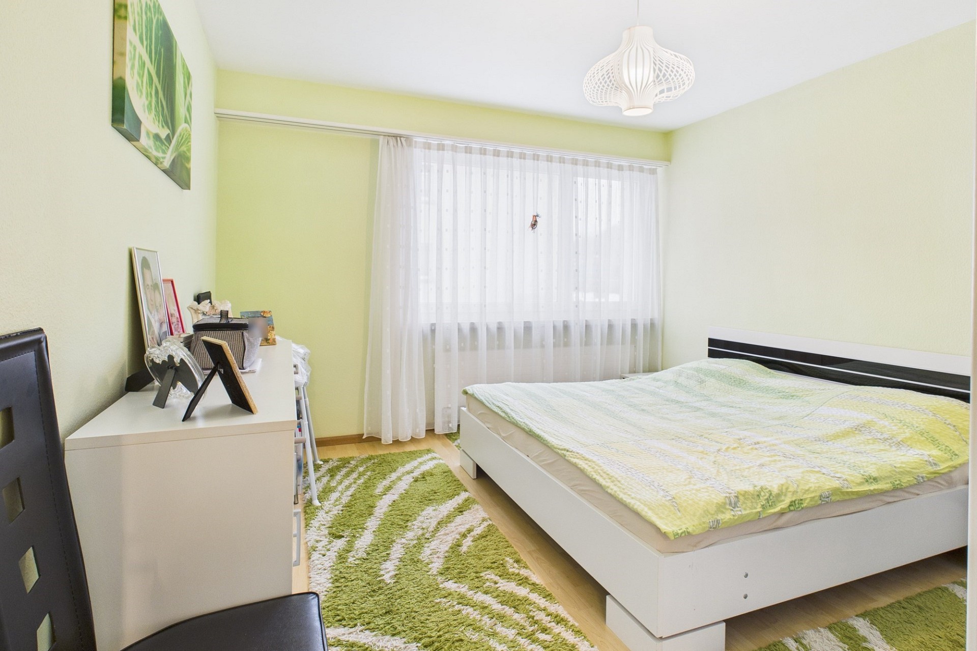 Helles Schlafzimmer mit grünem Akzent