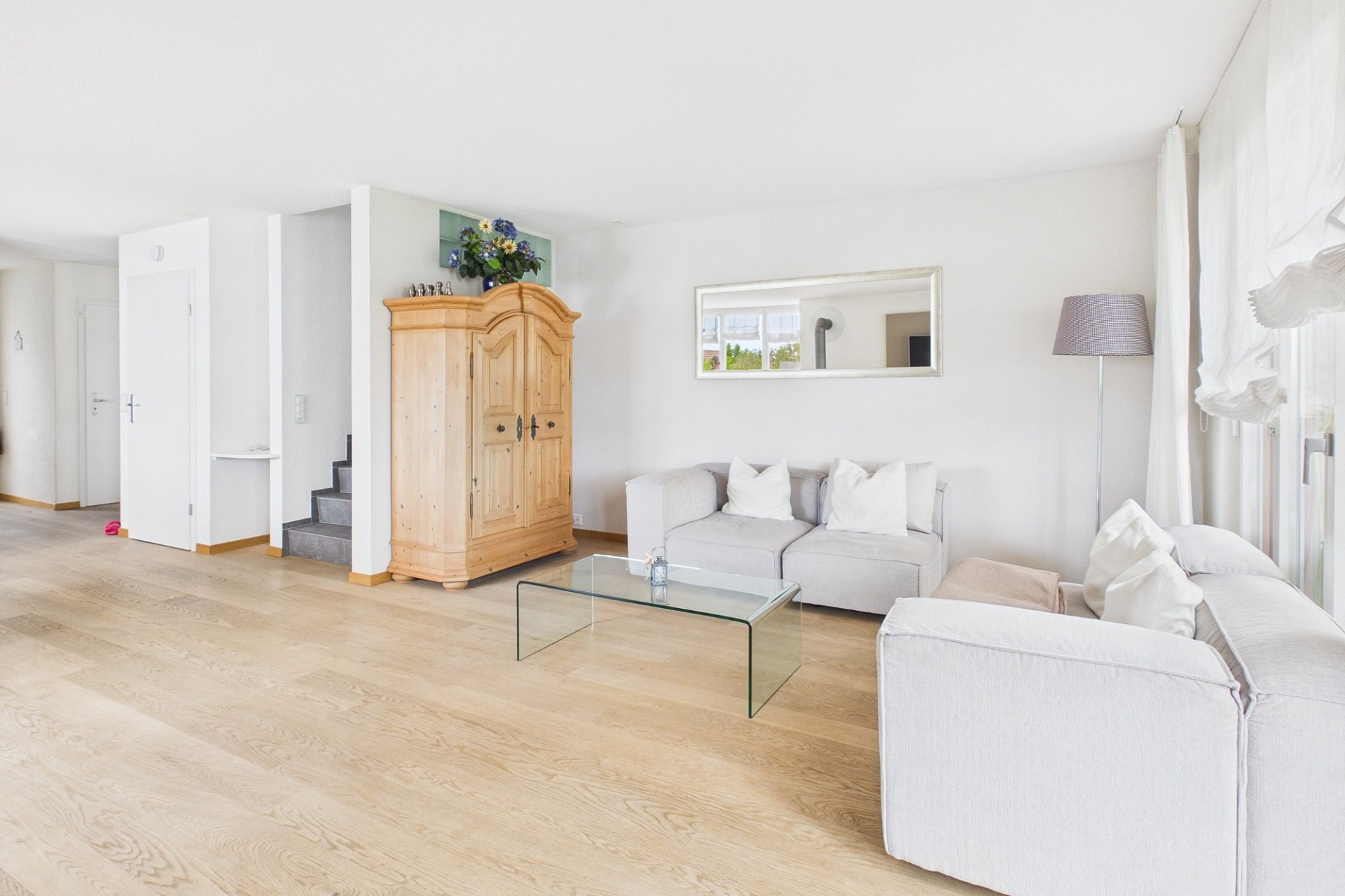 Helles Wohnzimmer mit Sofa und Holzschrank
