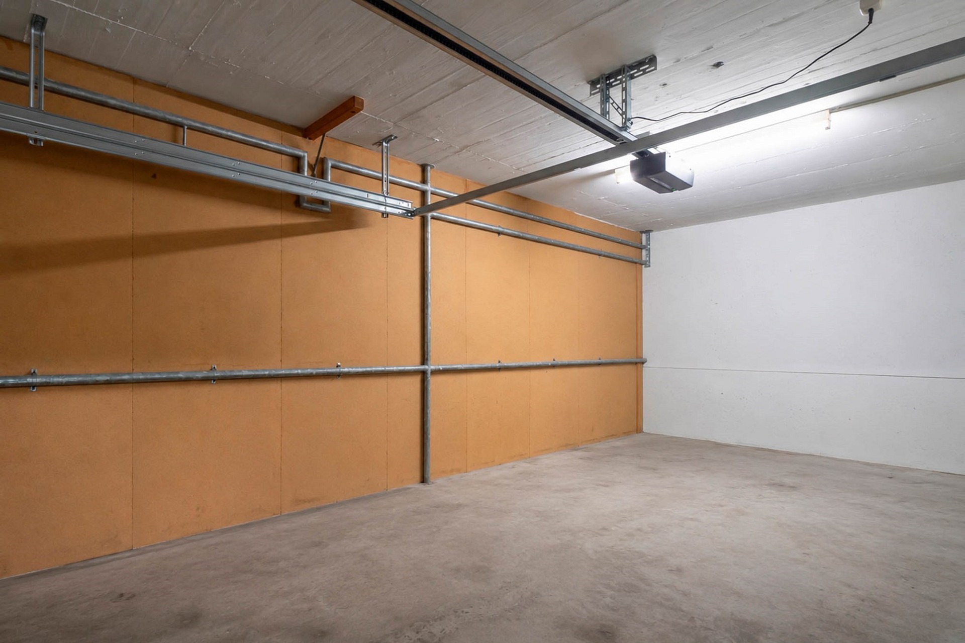 Leere Garage mit Betonboden und Wandregalen