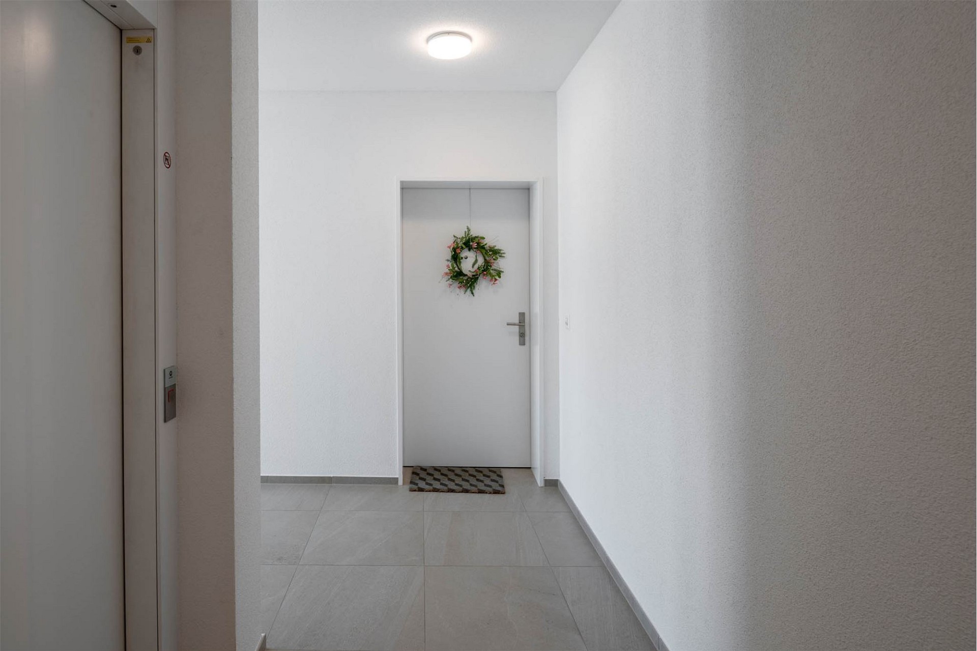 Heller Flur mit Aufzug und Tür