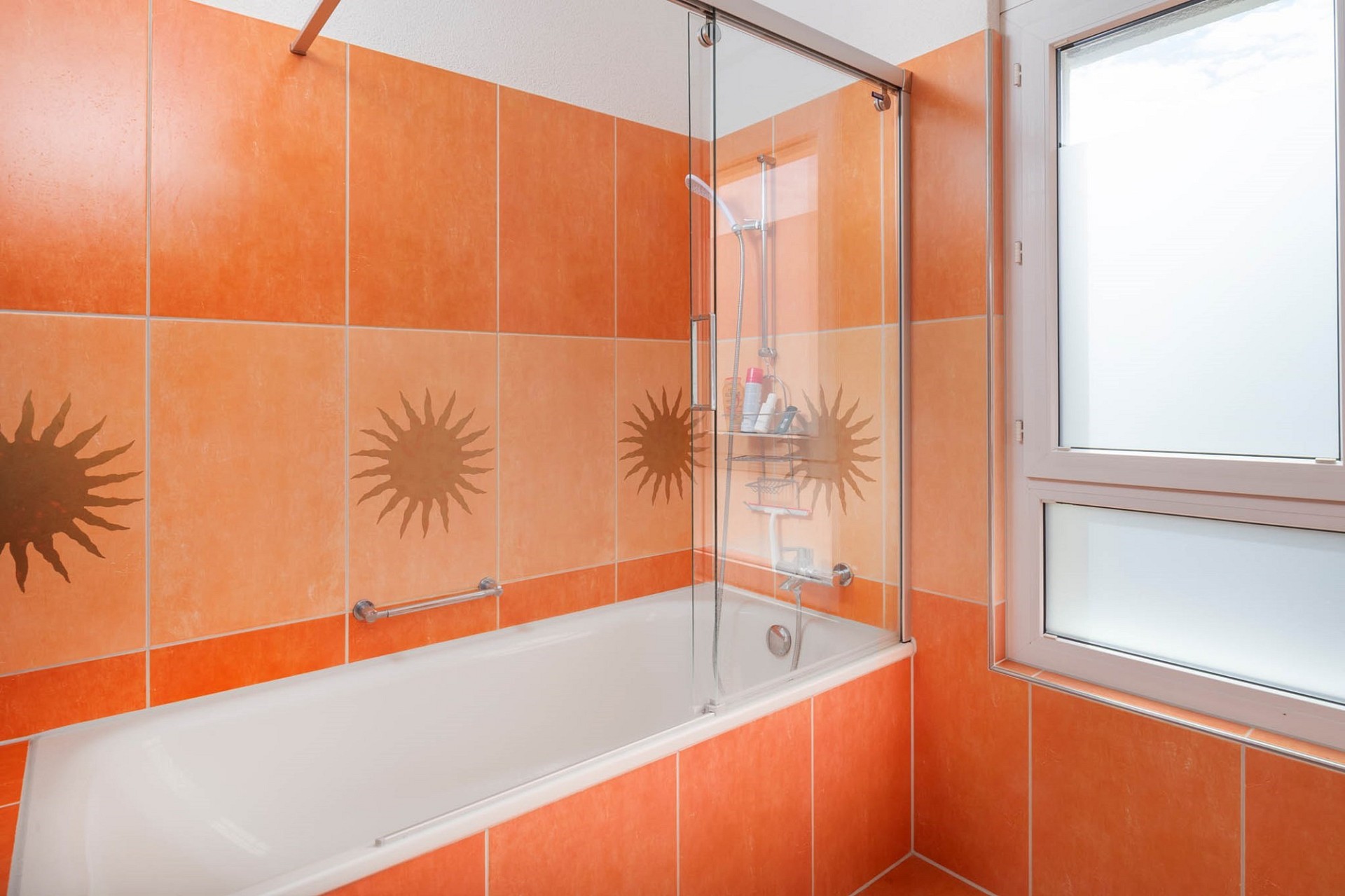 Badezimmer mit Badewanne und orangefarbenen Fliesen
