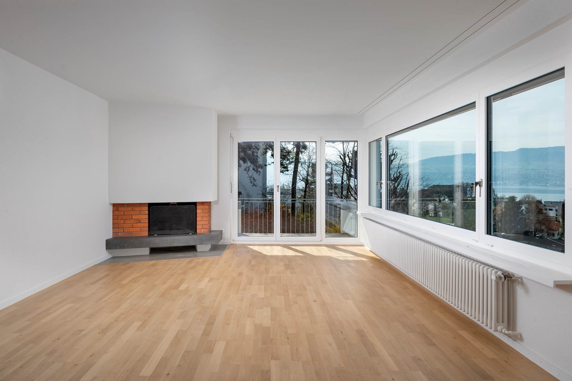 Heller Wohnraum mit Kamin und Seeblick