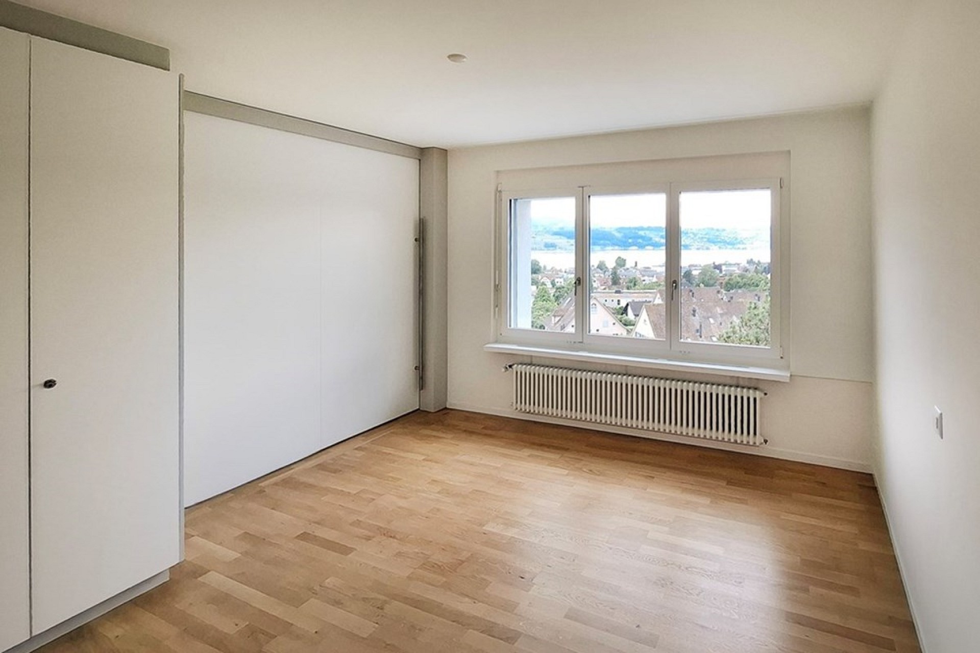 Helles, leeres Schlafzimmer mit Ausblick