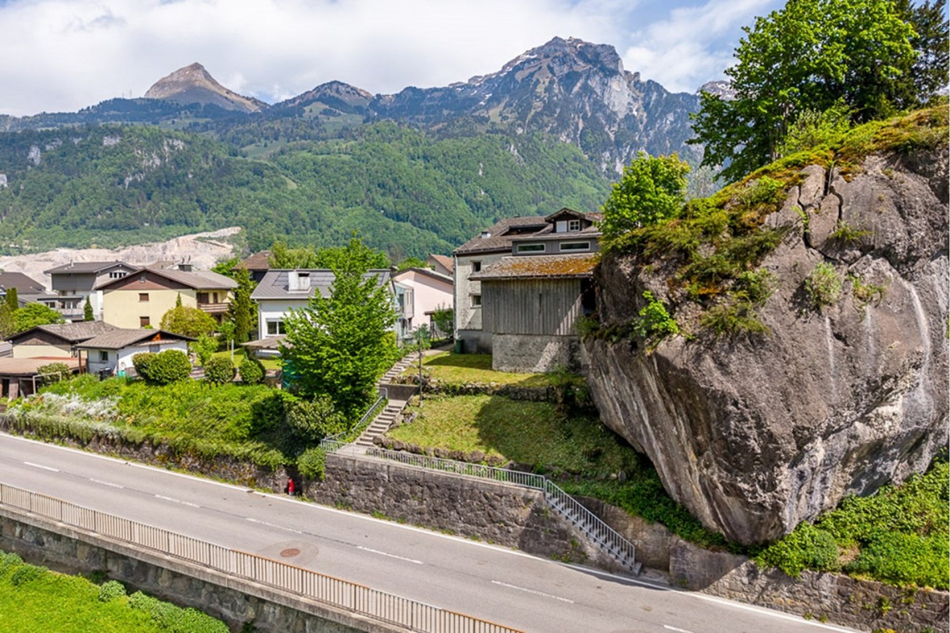 Alpenwohngebiet mit Blick auf Berge und Felsblock