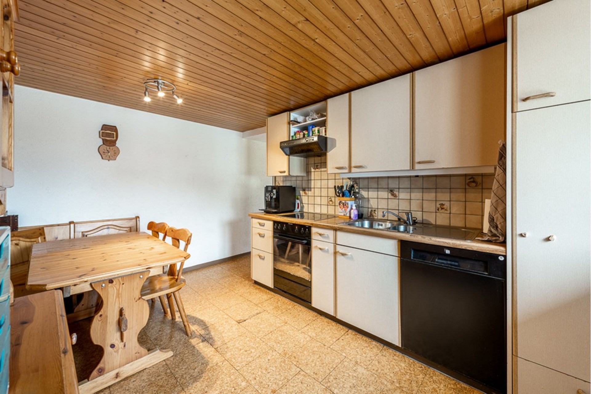 Küche mit Holzdecke und Esstisch