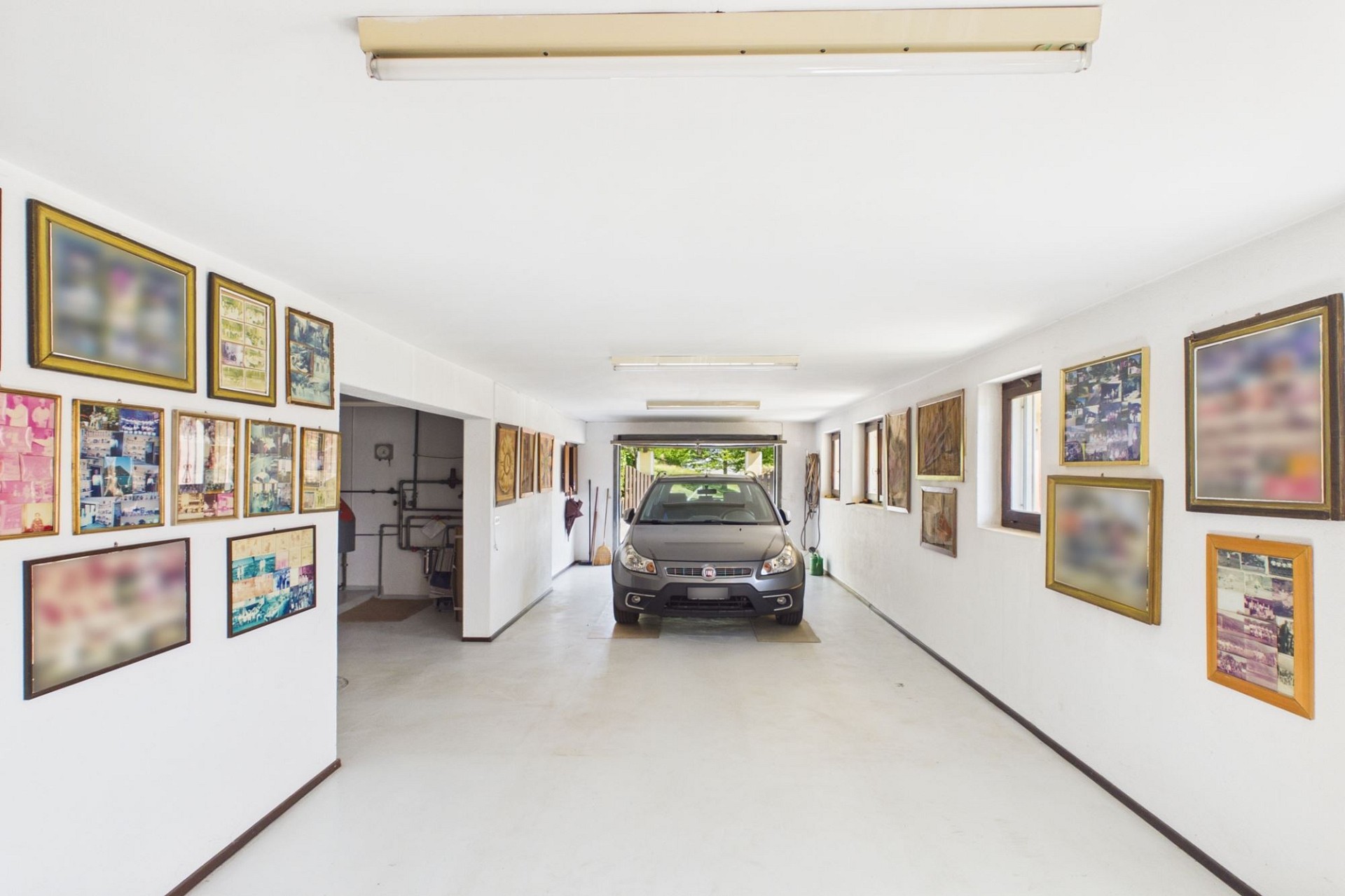 Garage mit geparktem Auto und Bildern an den Wänden