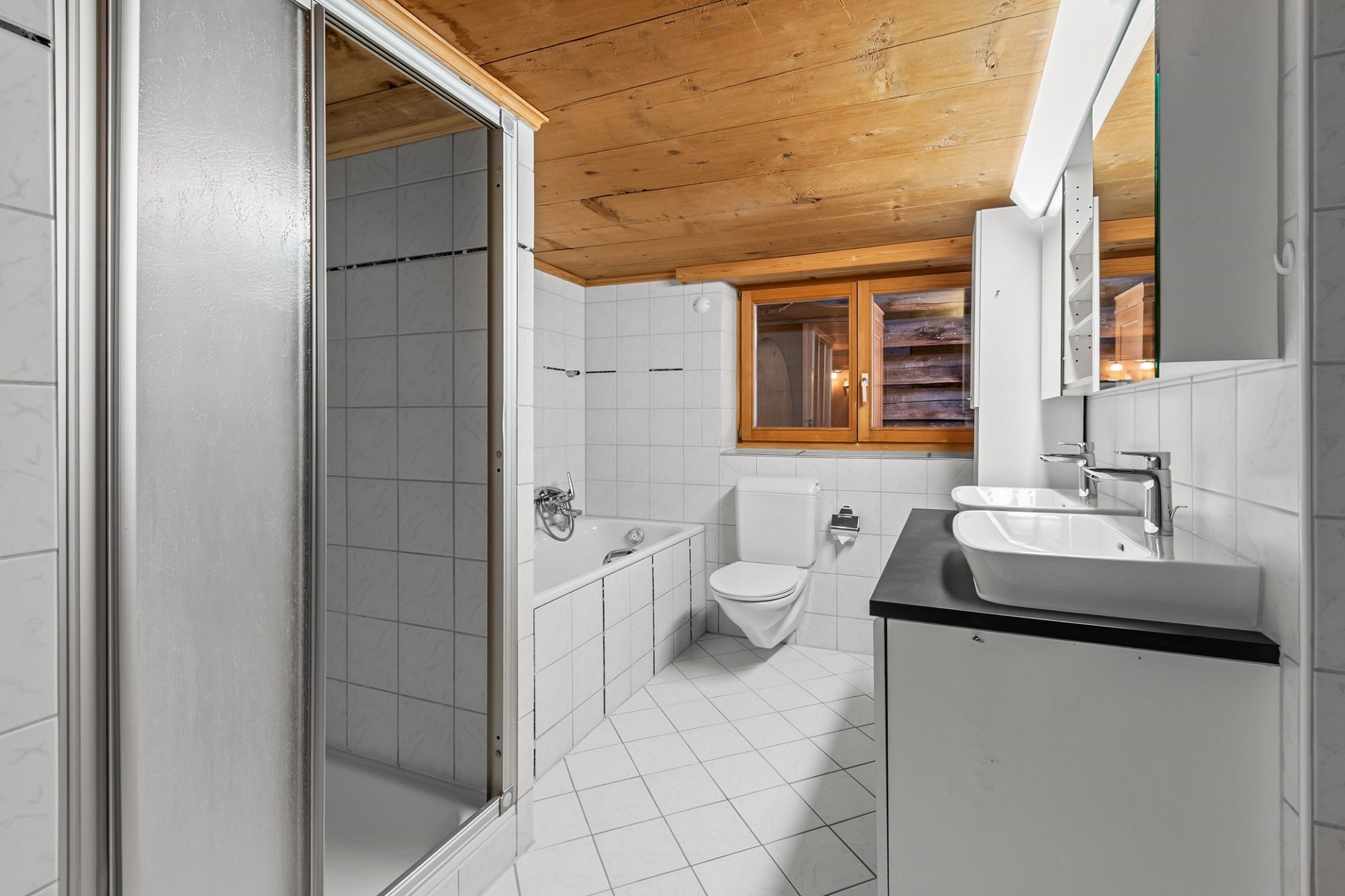 Badezimmer mit Holzdecke und Dachfenster