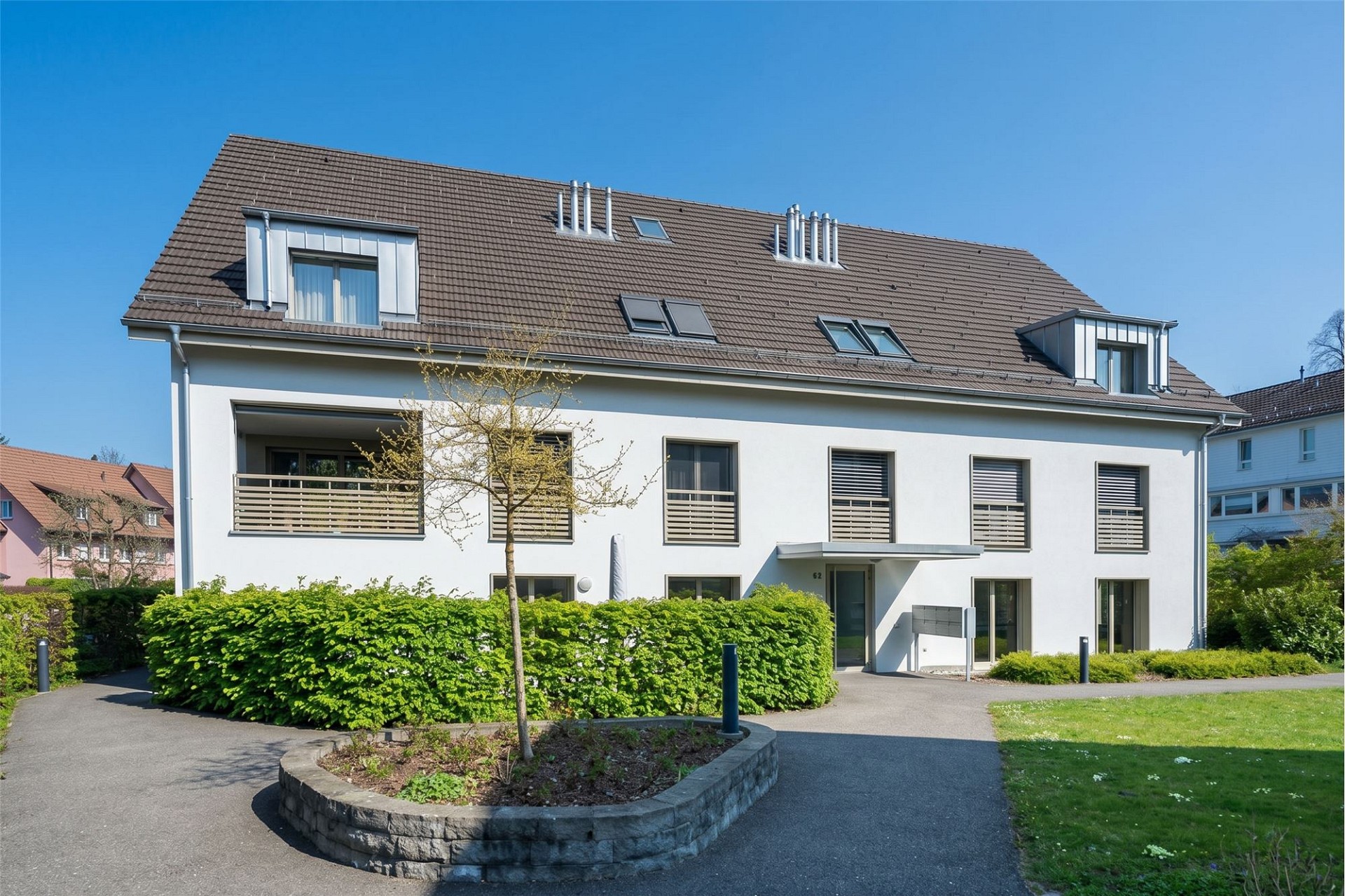 Mehrfamilienhaus mit Satteldach und weißer Fassade