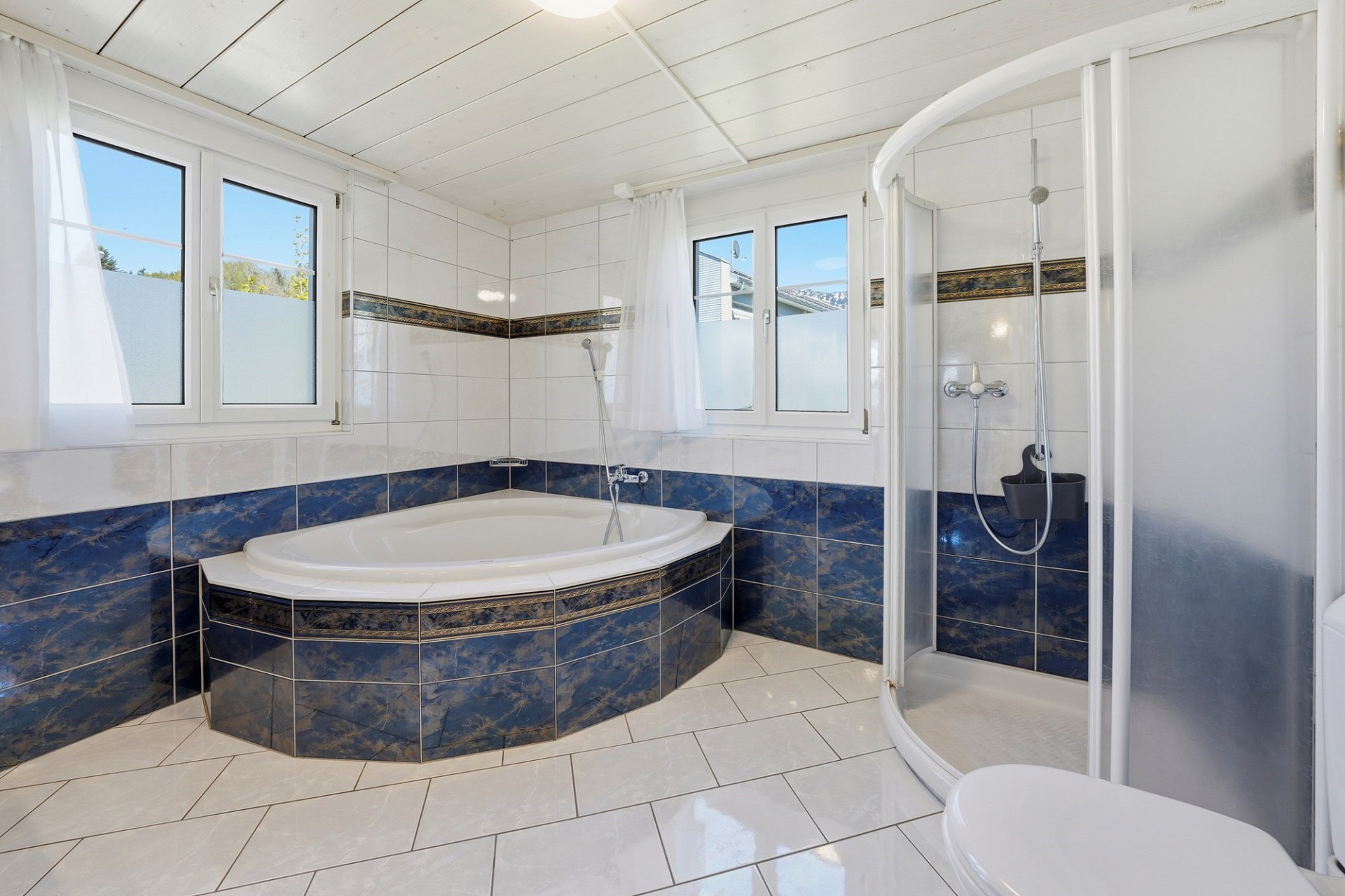 Helles Badezimmer mit Eckbadewanne und Dusche