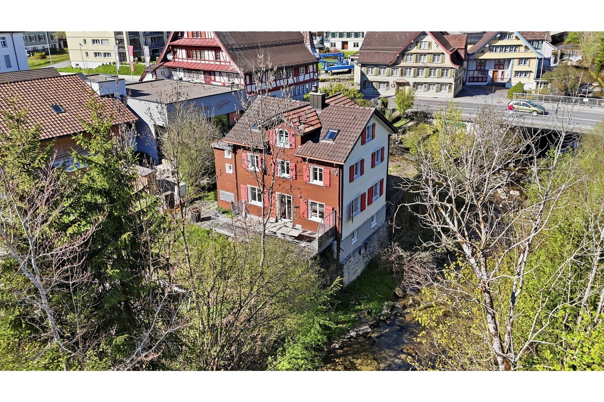Drohnenaufnahme eines Hauses am Bach