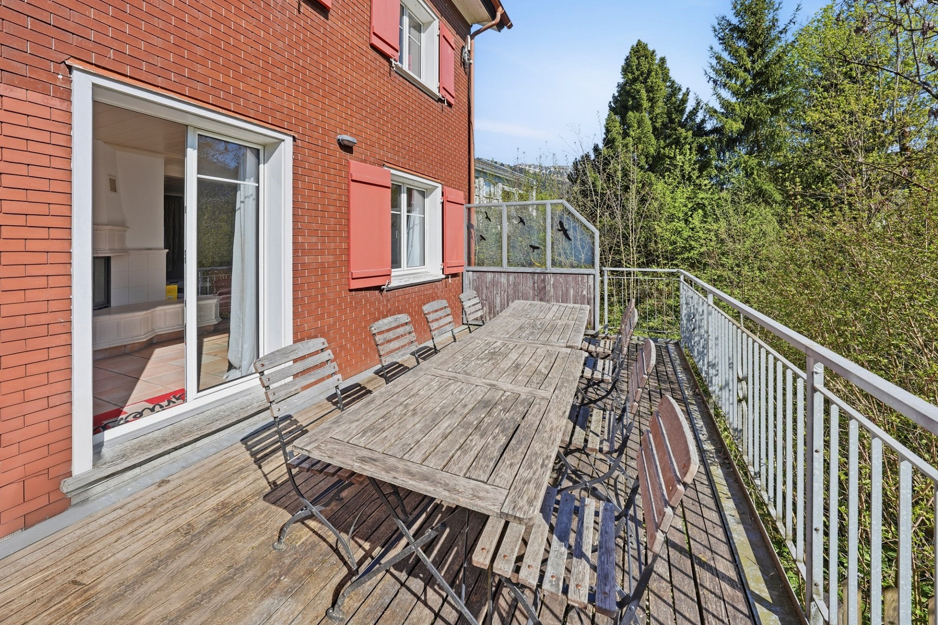Balkon mit Holzlounge und Blick ins Grüne