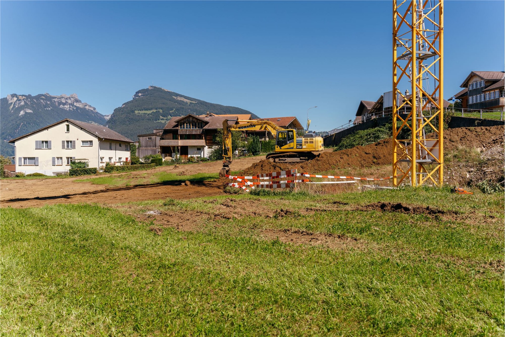 Bauplatz mit Kran und Bergpanorama
