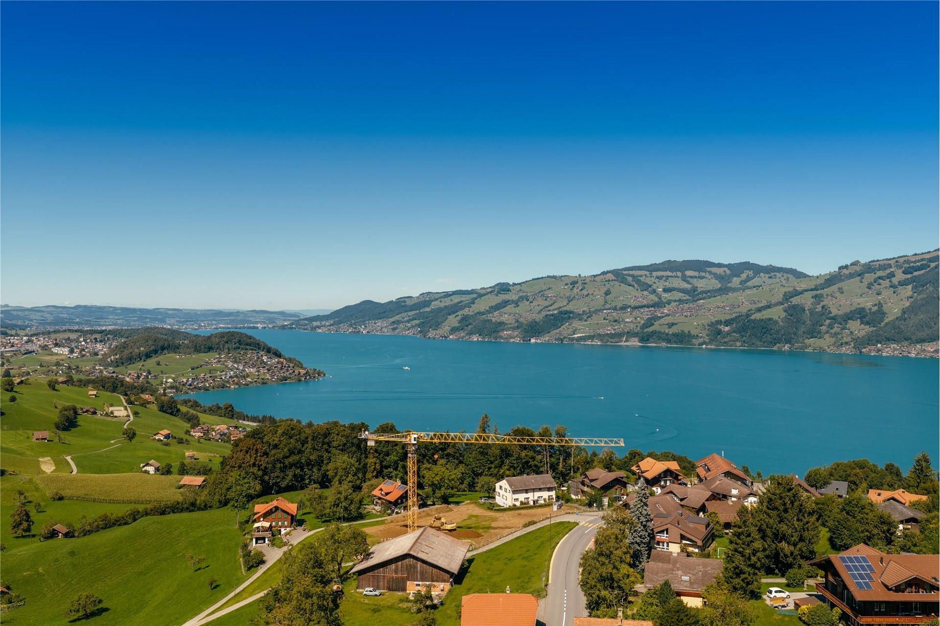Luftaufnahme einer Seen- und Berglandschaft mit Siedlung