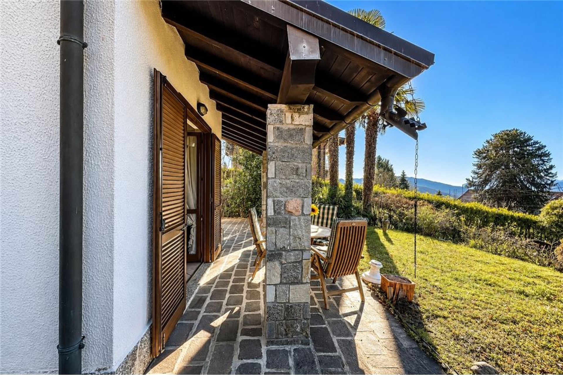 Überdachte Terrasse mit Gartenblick