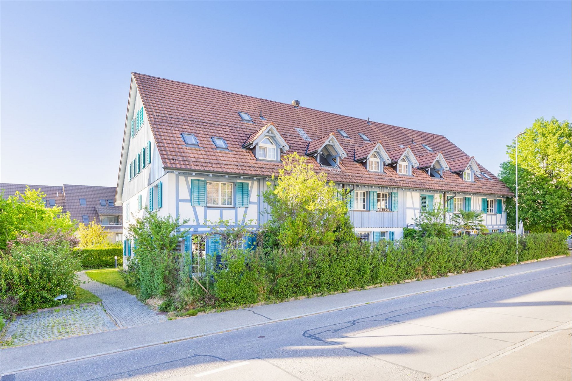 Wohnhaus mit rotem Satteldach und grünen Fensterläden