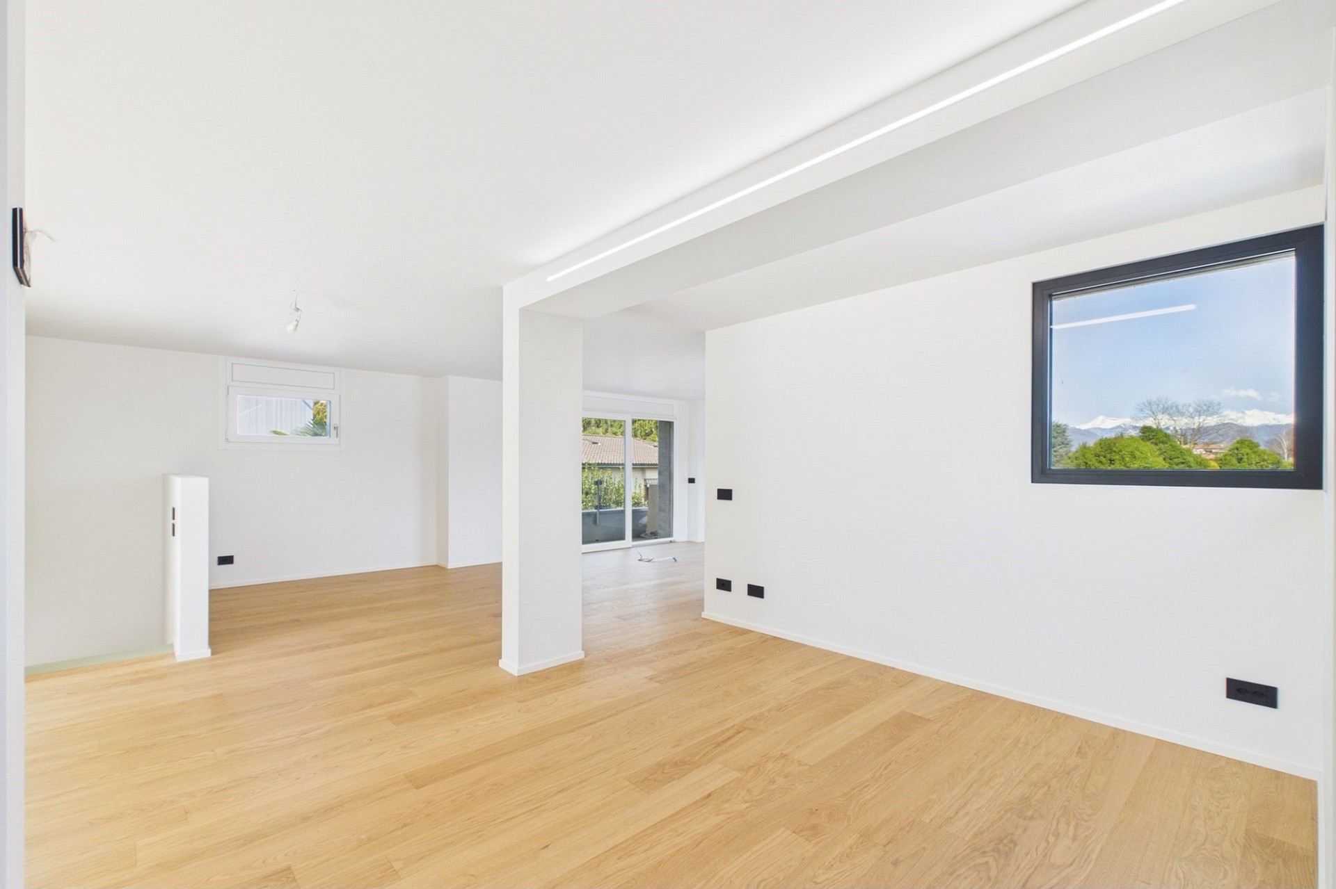 Heller, leerer Wohnraum mit Holzoptikboden
