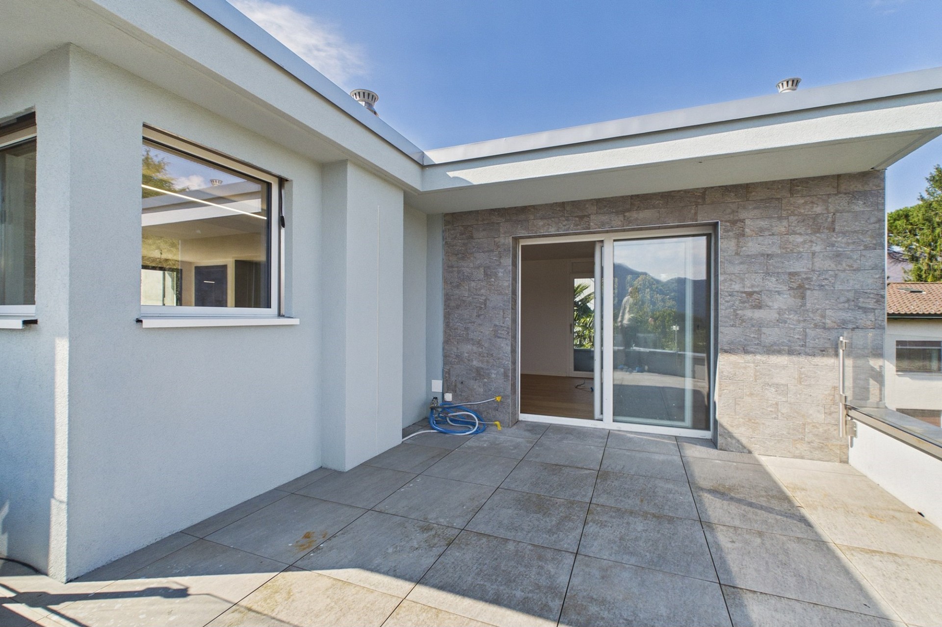 Moderne Dachterrasse mit großflächigen Glasöffnungen