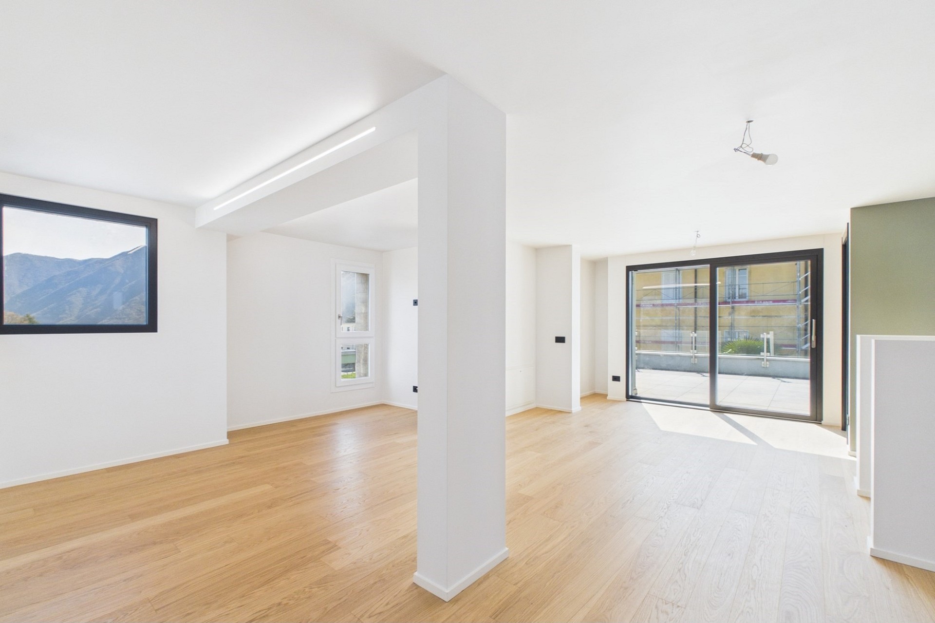 Heller, leerer Wohnraum mit großer Fensterfront