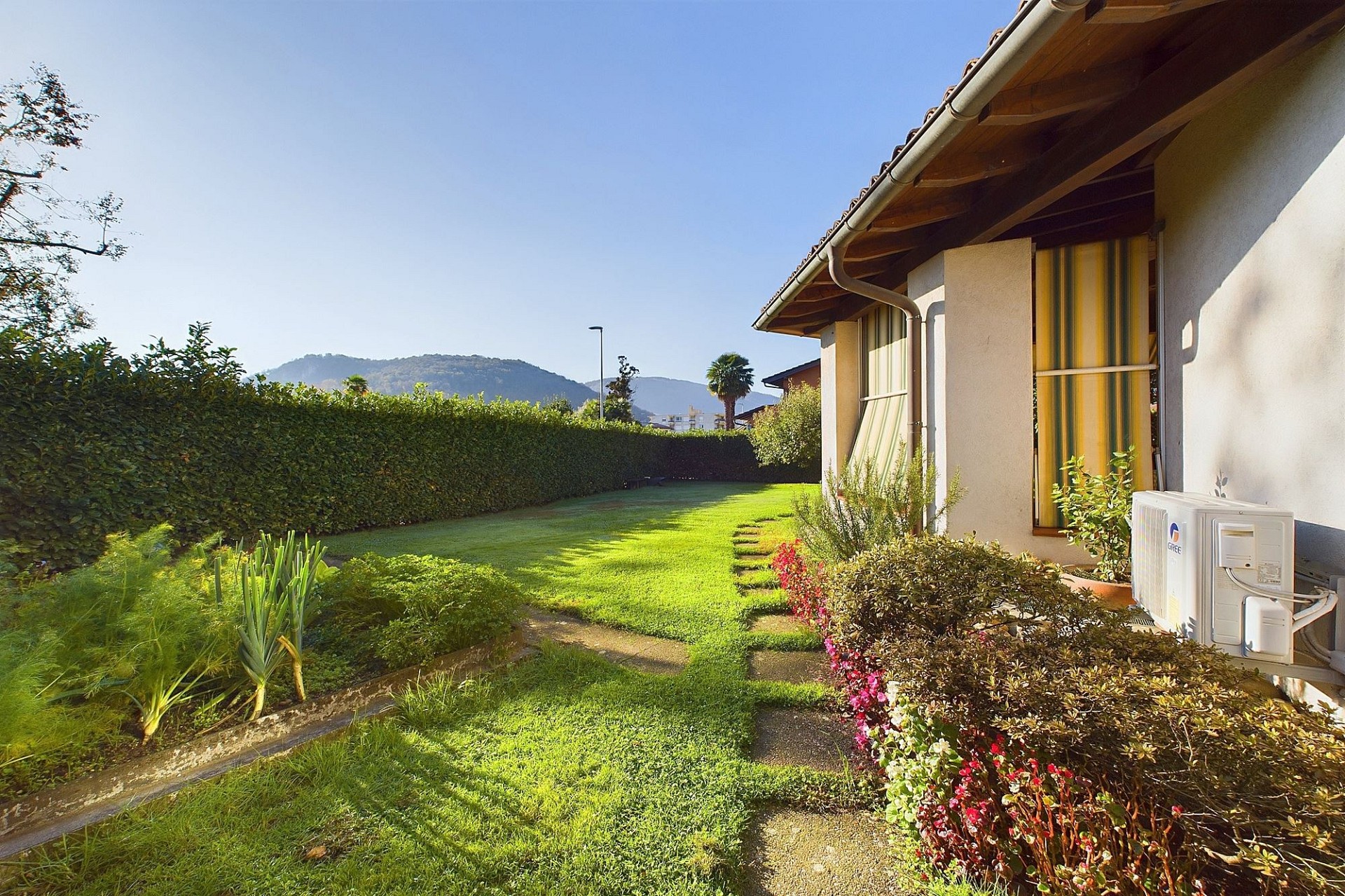 Gartenansicht mit Hausseite und Bergblick