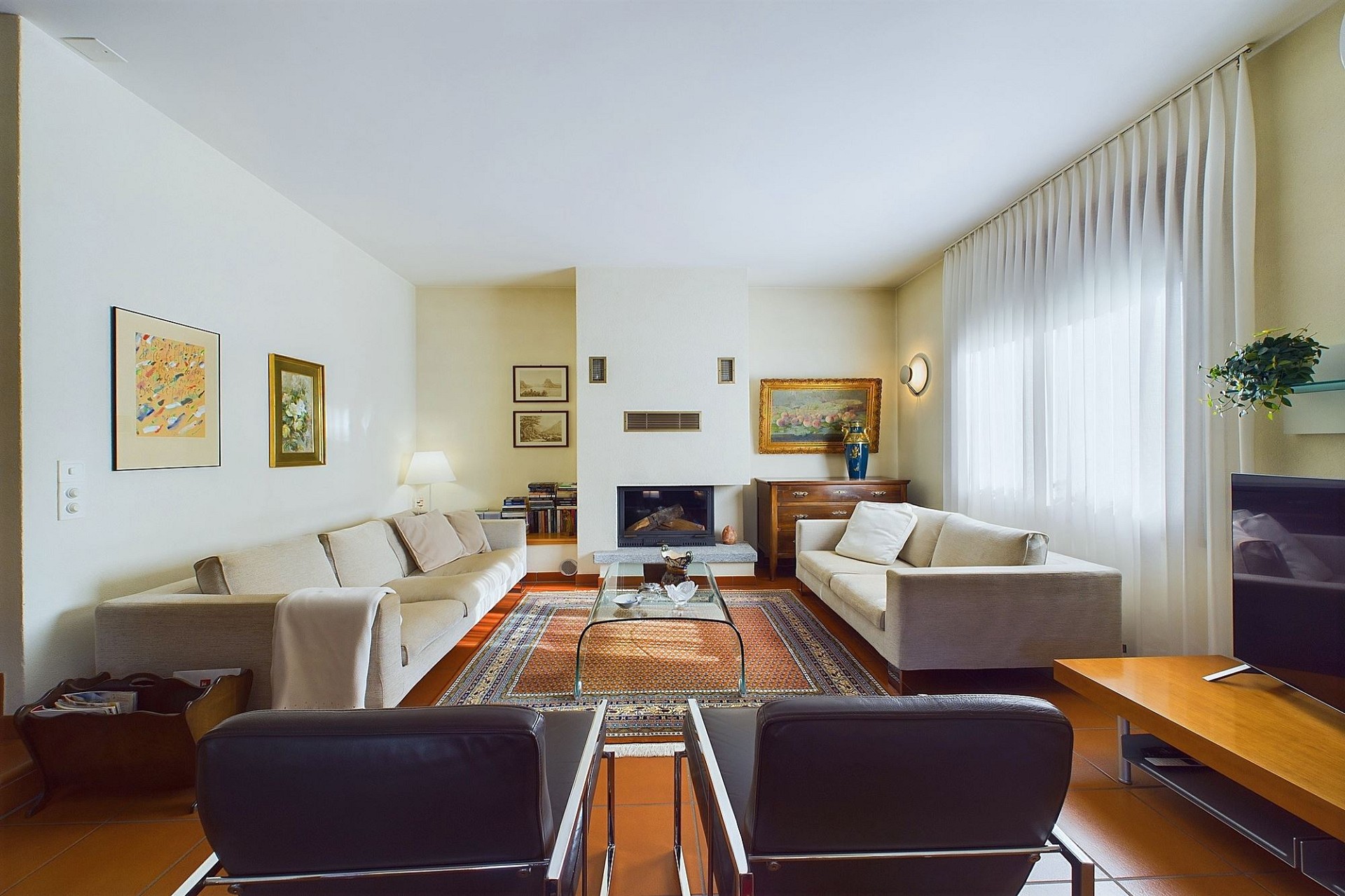 Helles Wohnzimmer mit Kamin und zwei Sofas