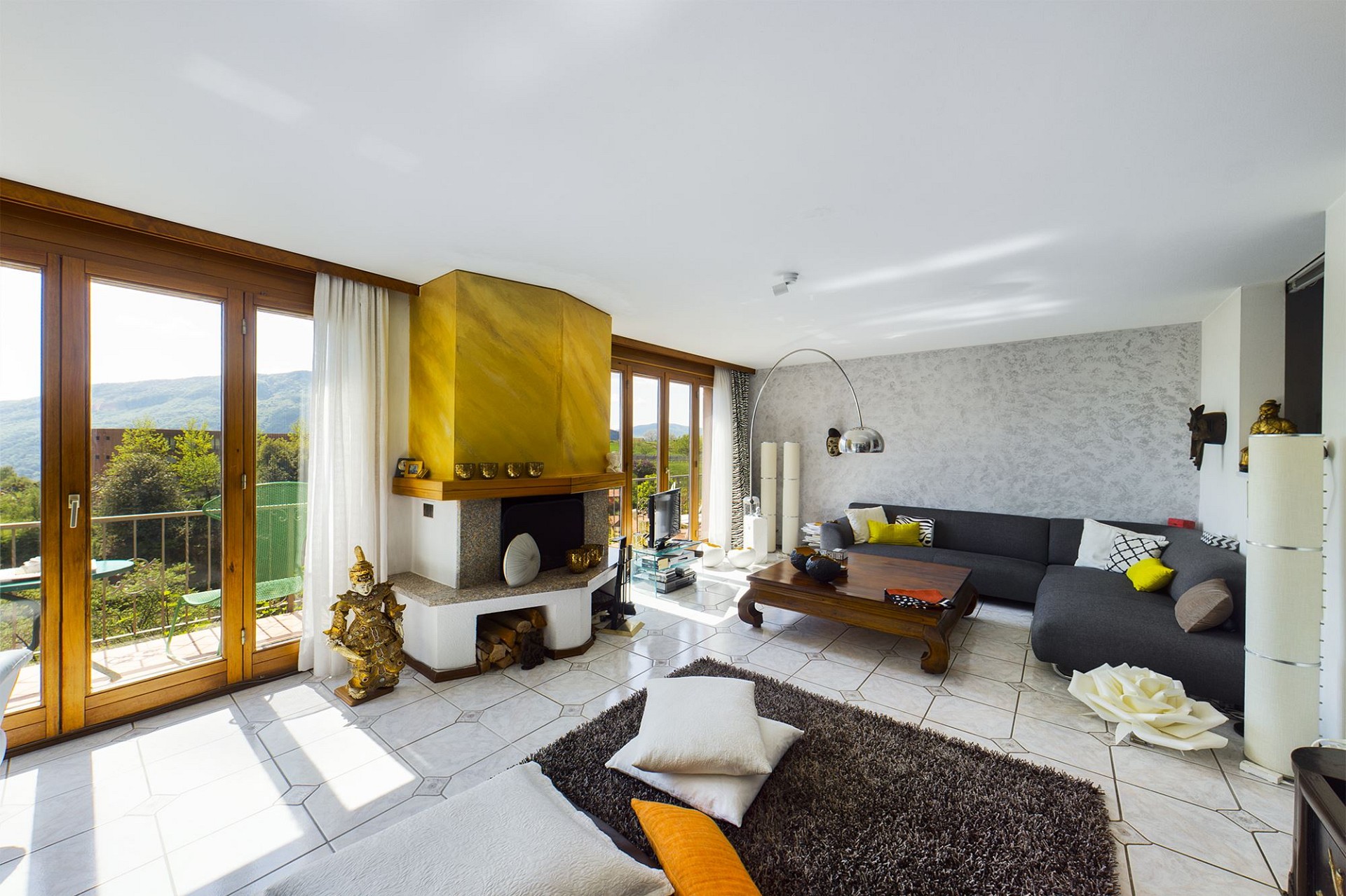 Helles Wohnzimmer mit Kamin und Balkonblick