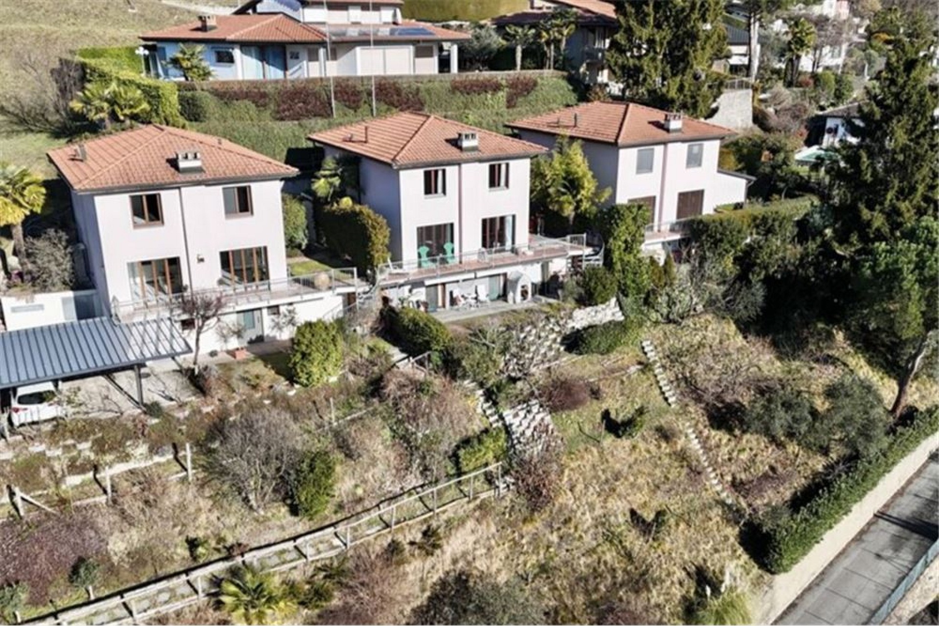 Luftaufnahme von drei Reihenhäusern mit Terrassen und Gartenanlagen