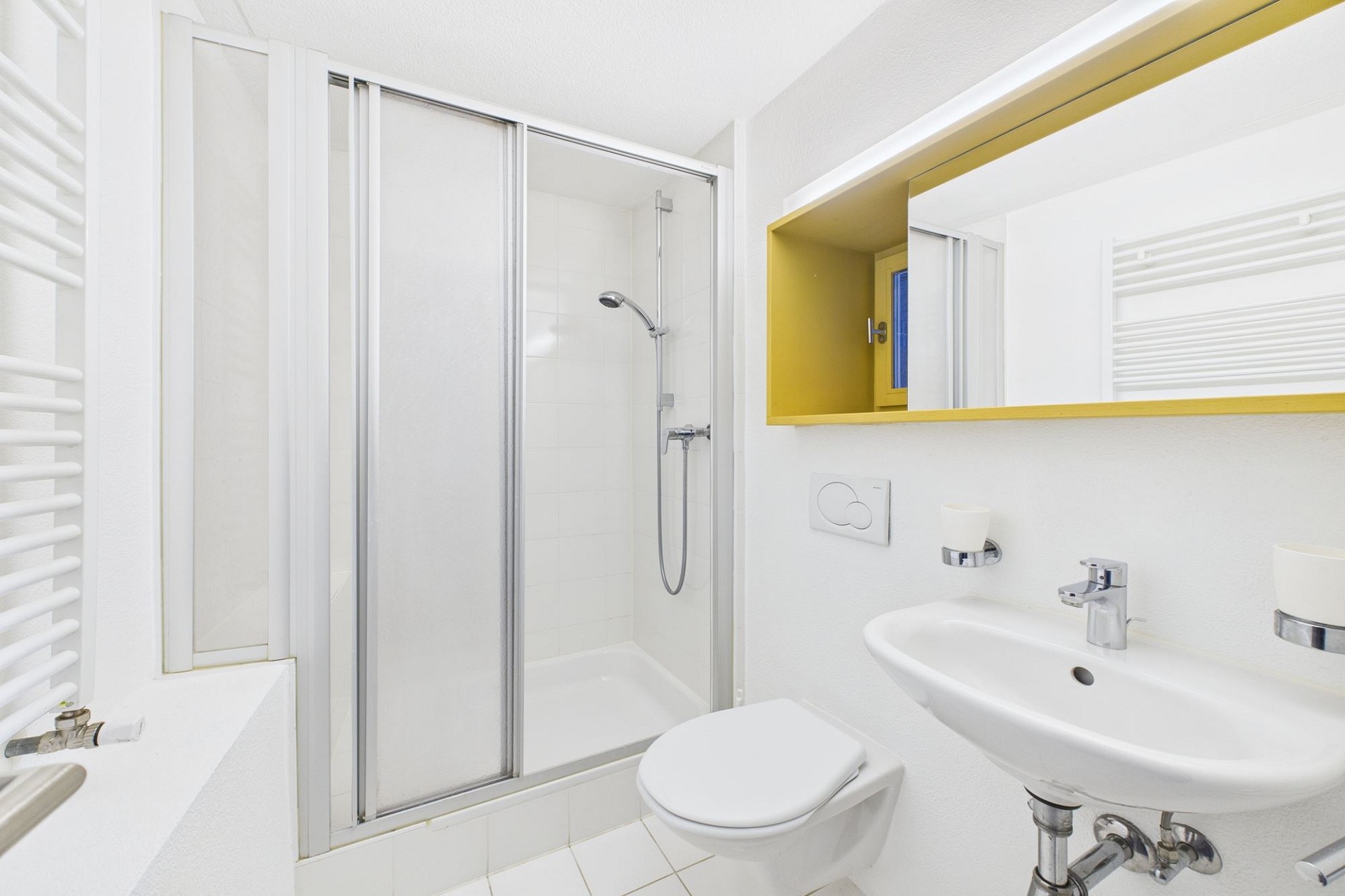 Kleines weißes Badezimmer mit Dusche und Waschtisch