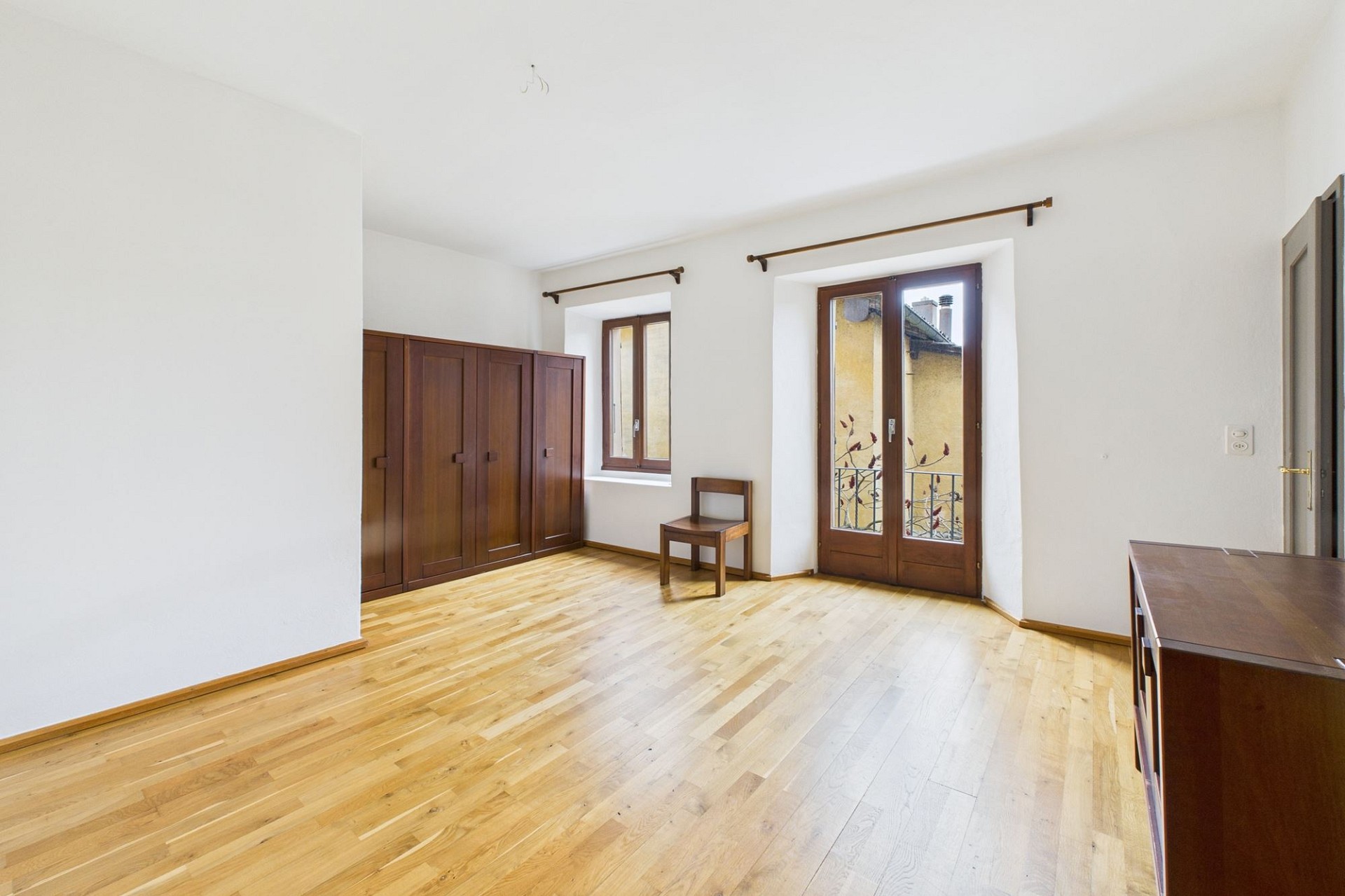 Heller leerer Raum mit Holzboden und Einbauschrank