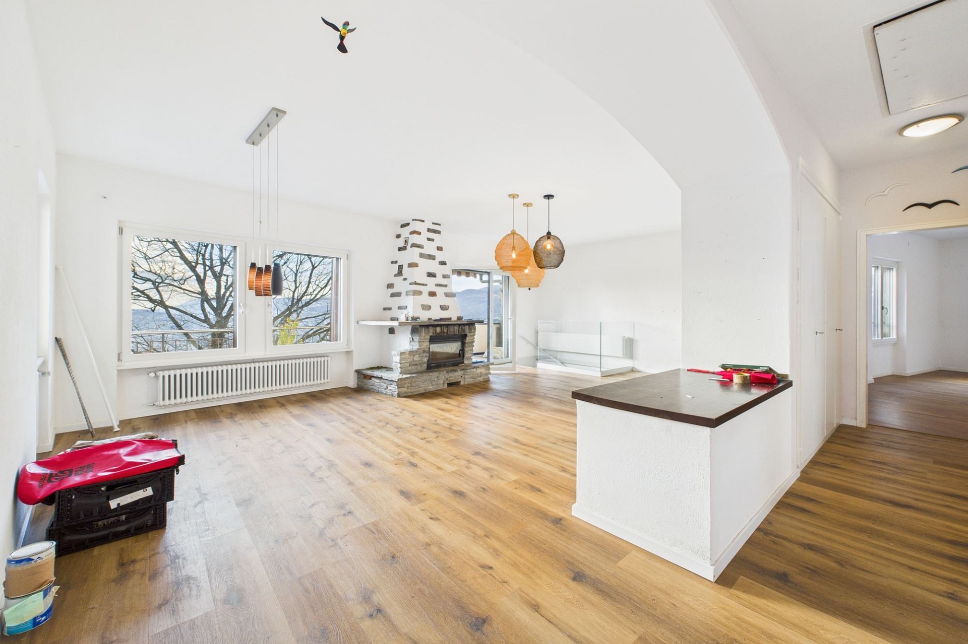 Helles Wohn-Esszimmer mit Kamin und Panoramablick