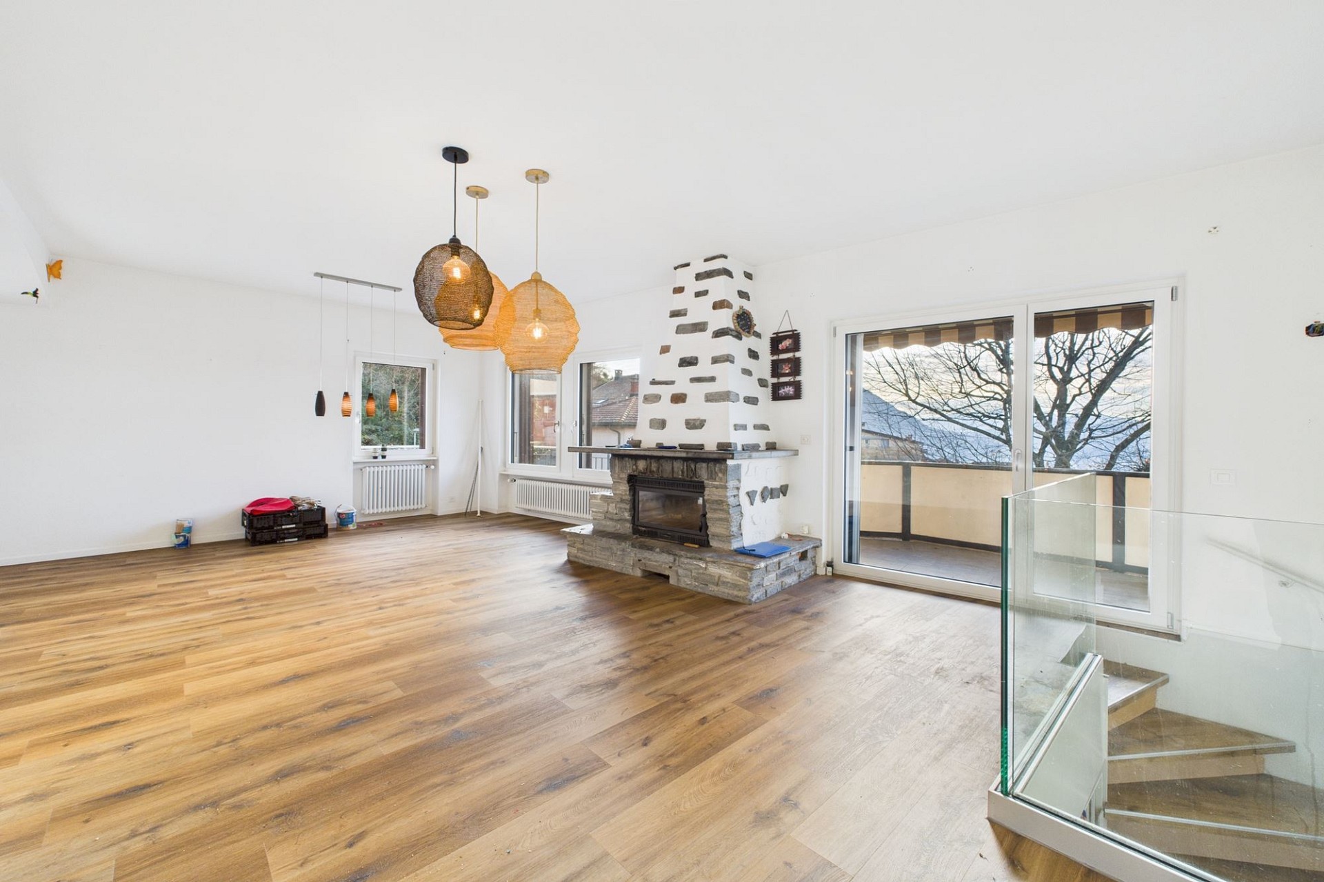 Heller Wohnraum mit Kamin und Balkonzugang