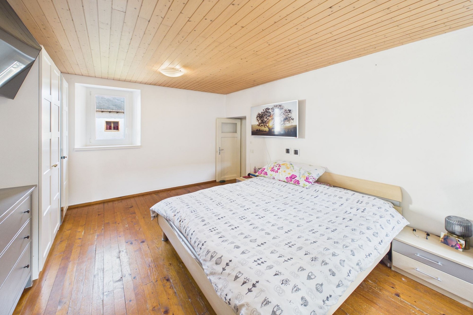 Helles Schlafzimmer mit Holzboden und Holzdecke