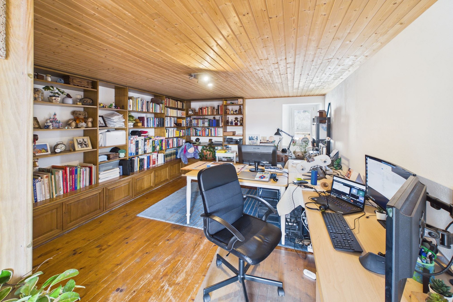 Arbeitszimmer mit Holzvertäfelung und Regalsystem