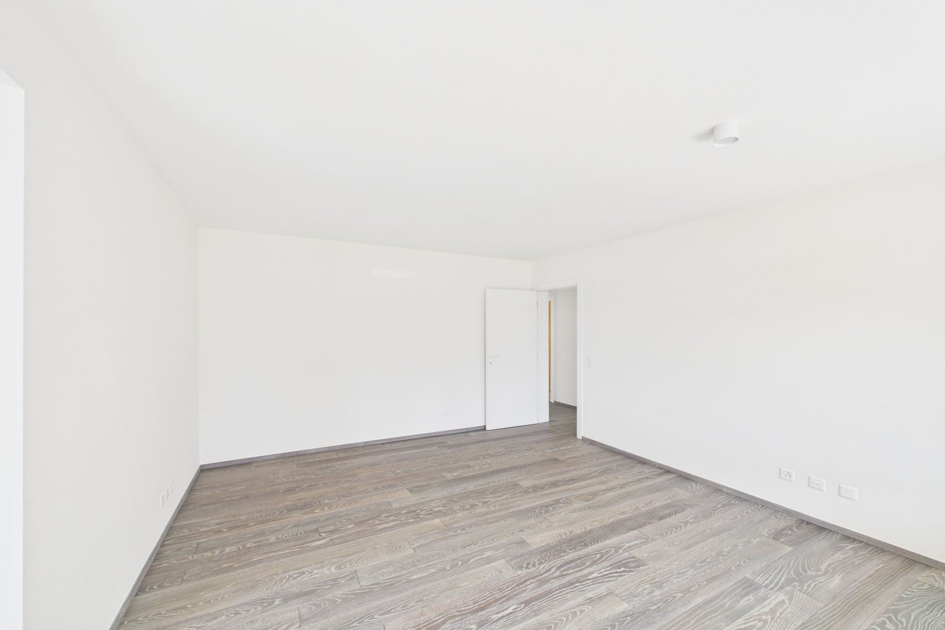Leerer heller Raum mit Holzoptik-Boden