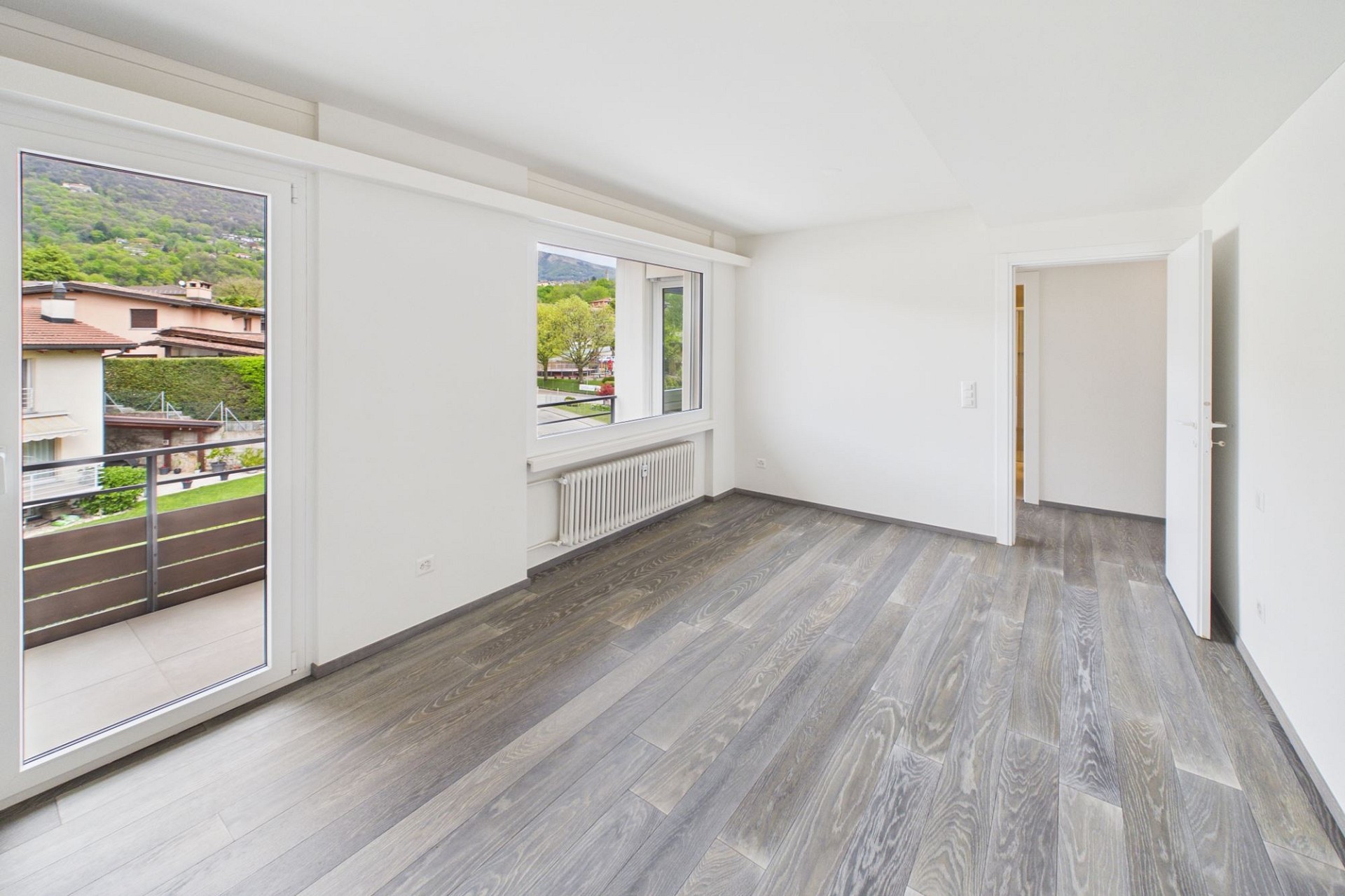 Heller leerer Wohnraum mit Balkon und Bergblick