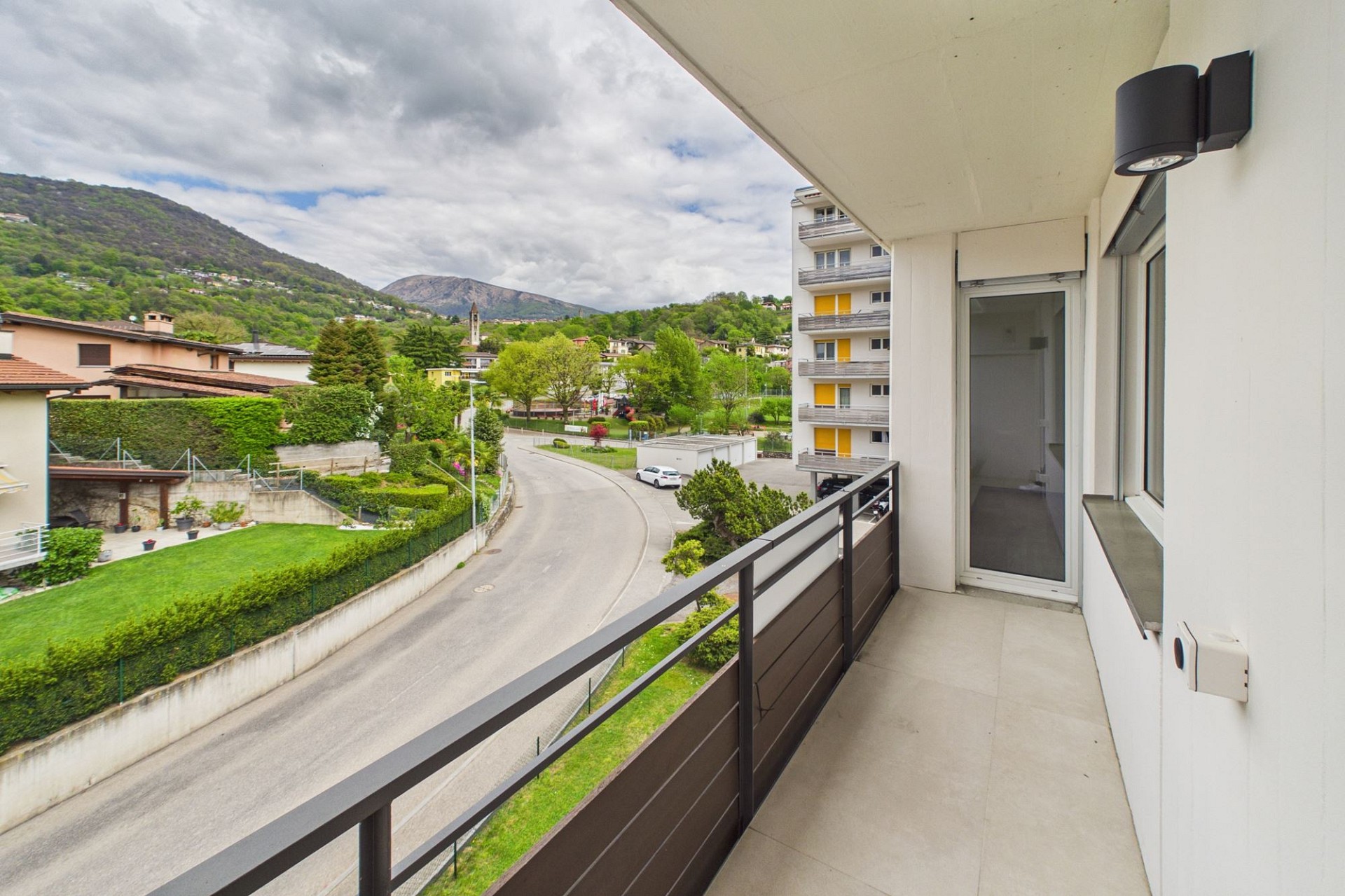 Balkon mit Ausblick auf Wohngebiet und Berge