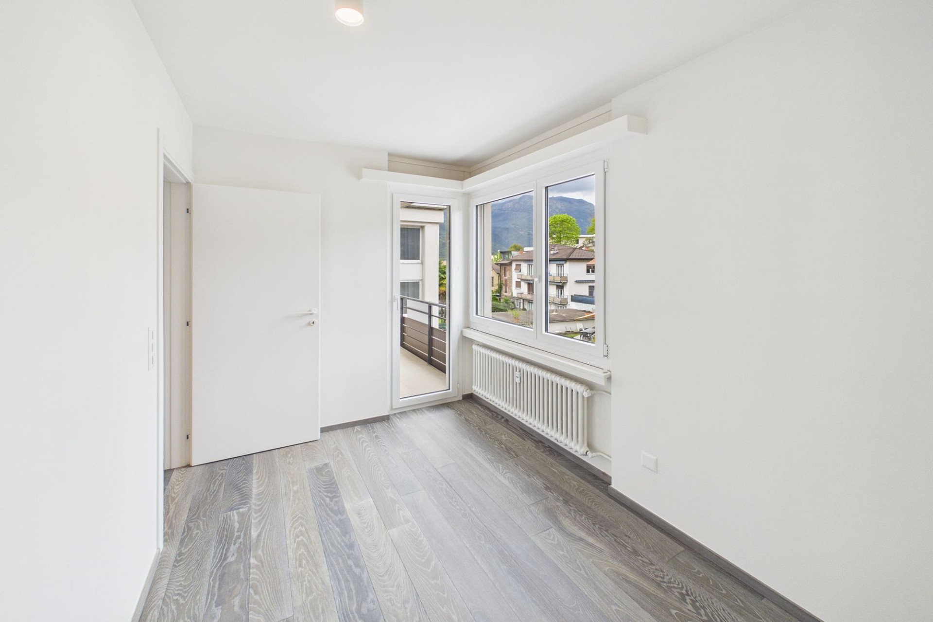 Helles, leeres Zimmer mit Balkon und Bergblick