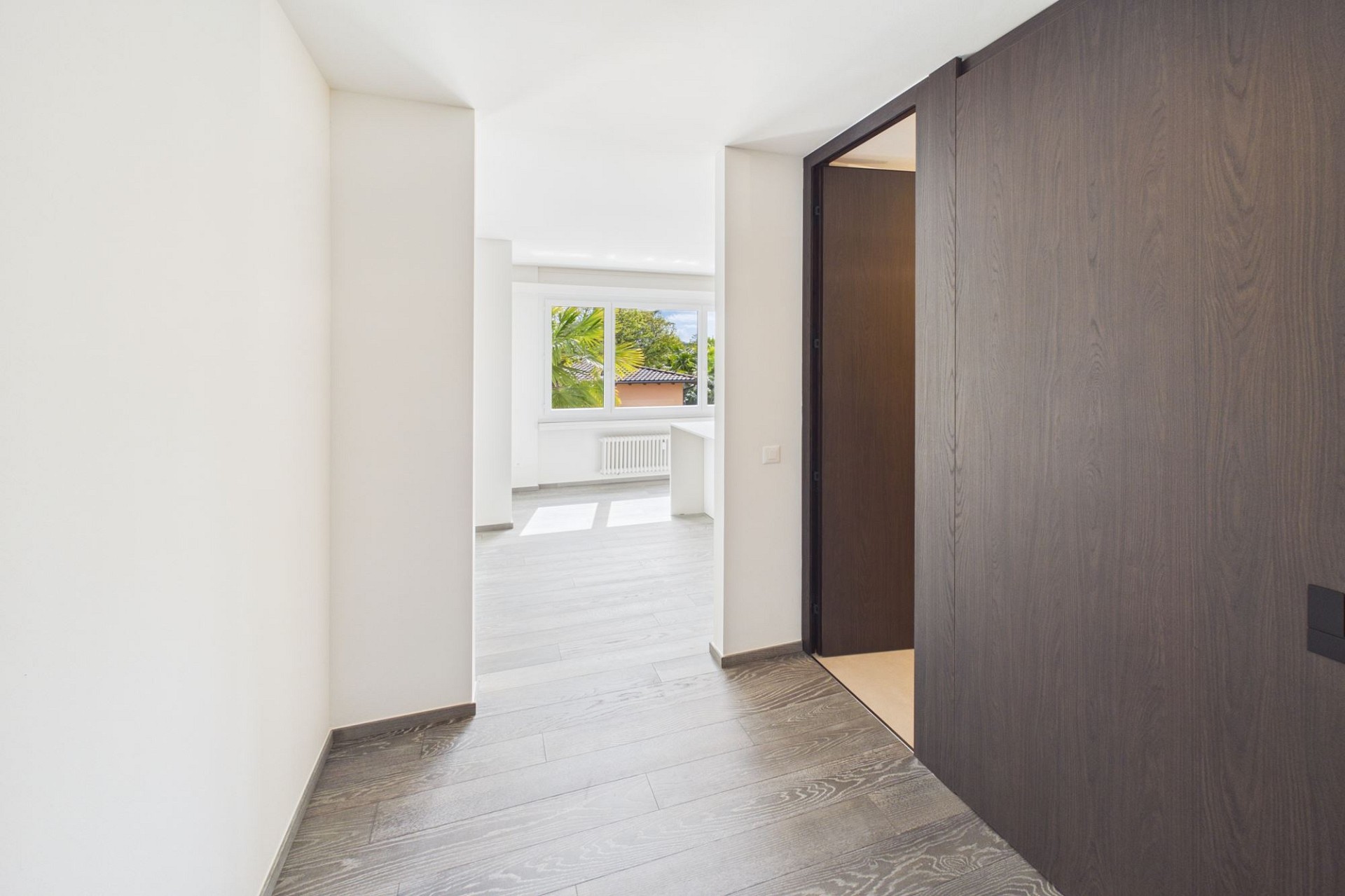 Heller Flur mit Blick in einen Wohnraum