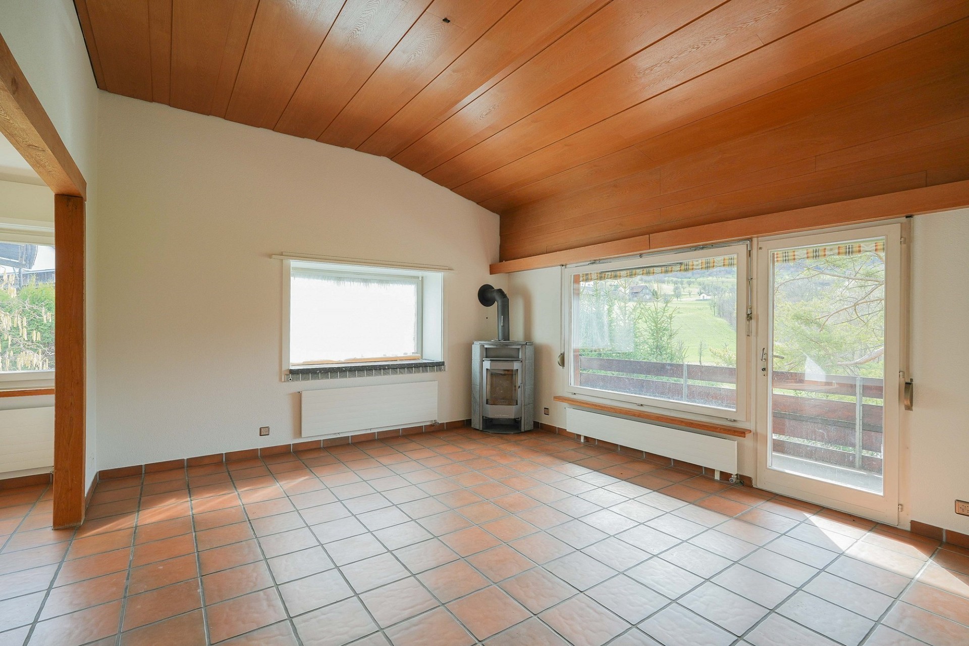 Heller Wohnraum mit Kaminofen und Terrassentür
