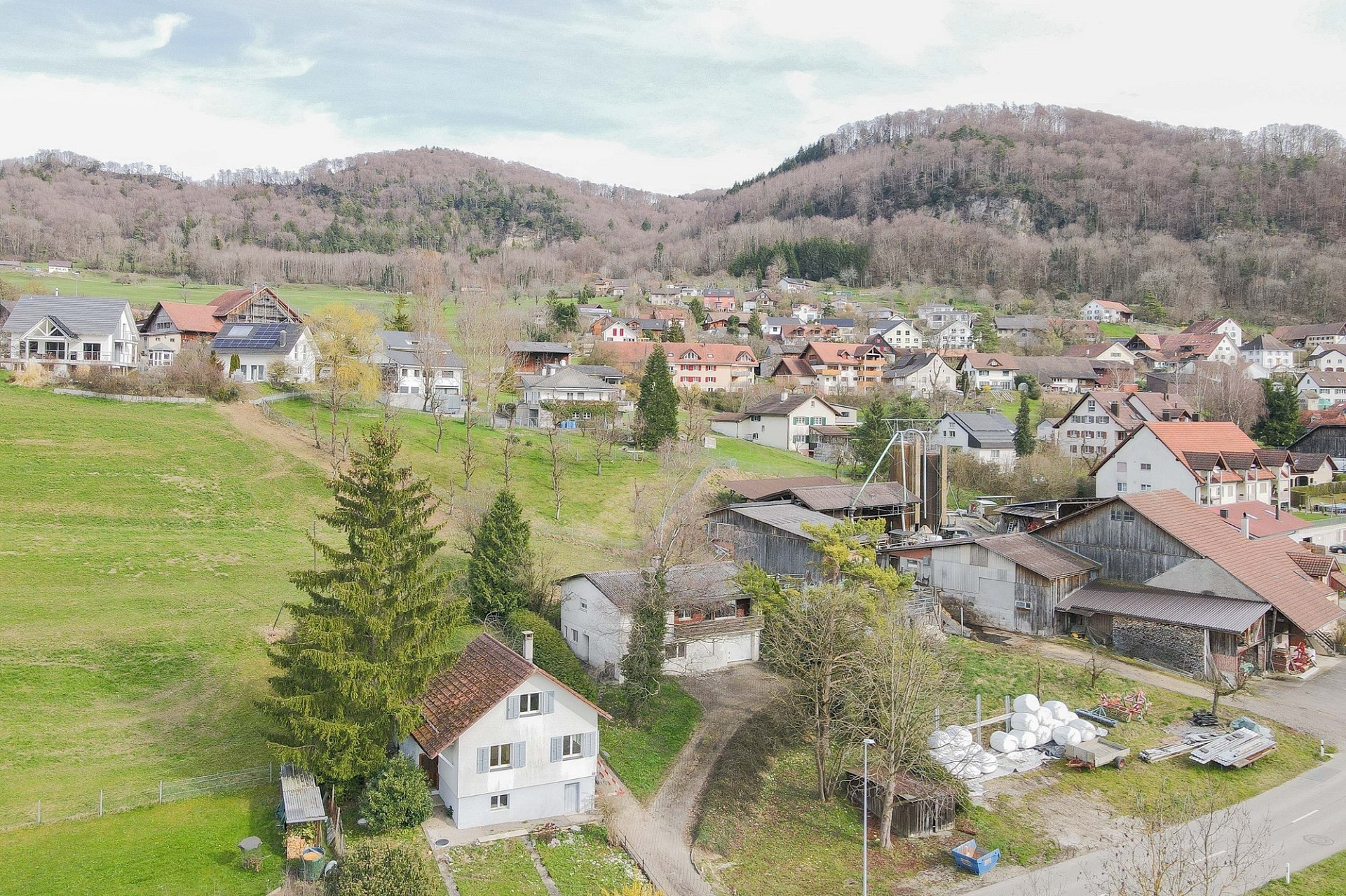 Luftaufnahme eines ländlichen Dorfes mit Bergkulisse