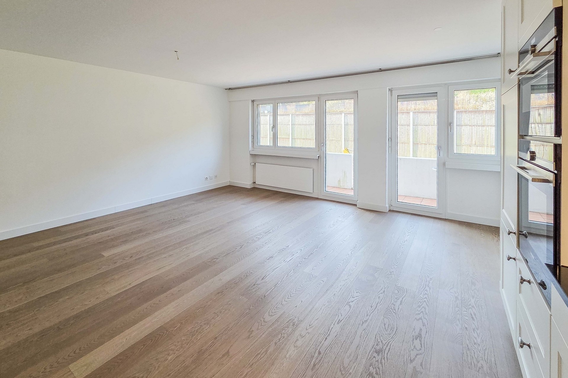 Heller leerer Wohnraum mit Balkon-/Terrassenzugang