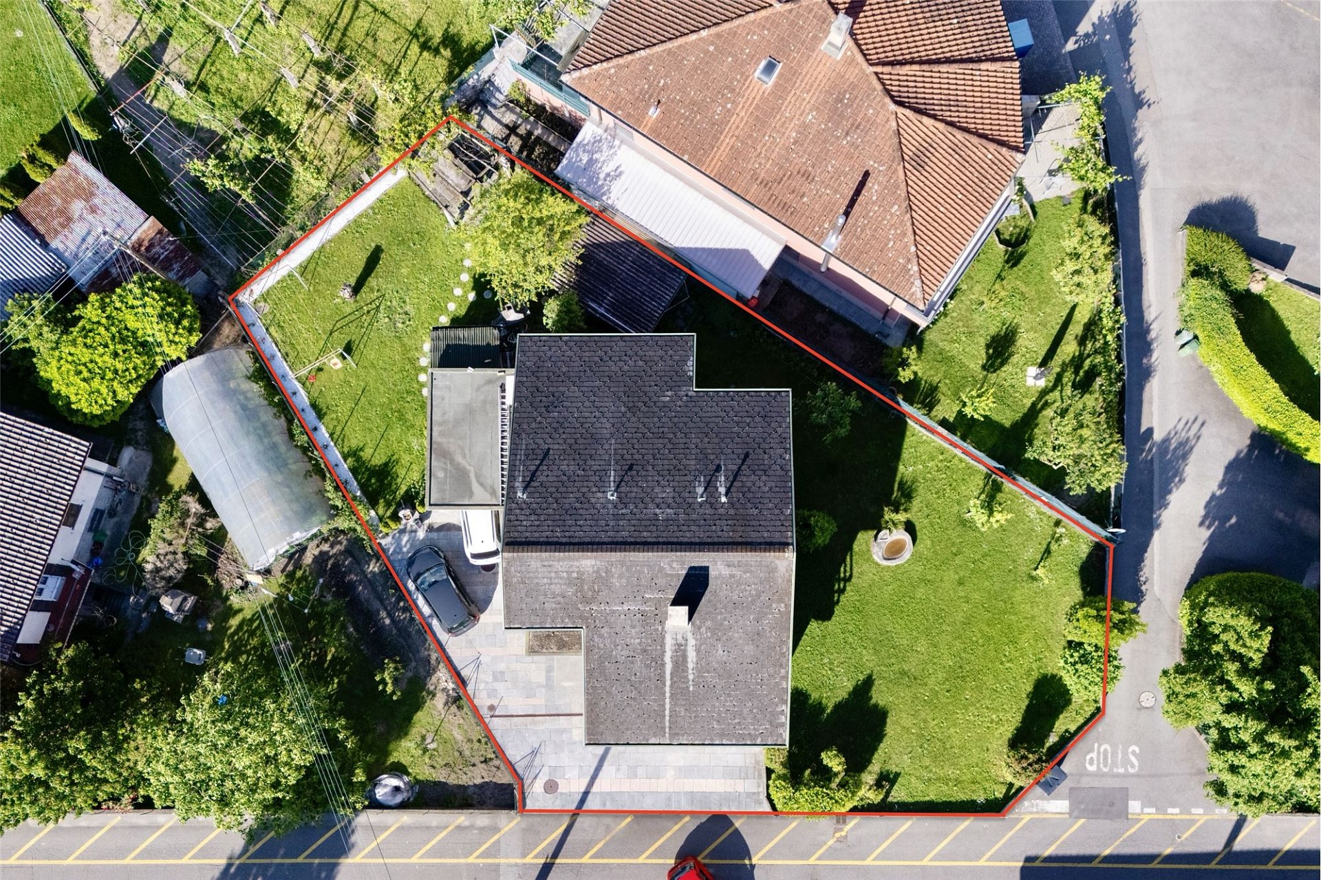 Luftaufnahme eines Einfamilienhauses mit eingezäuntem Garten