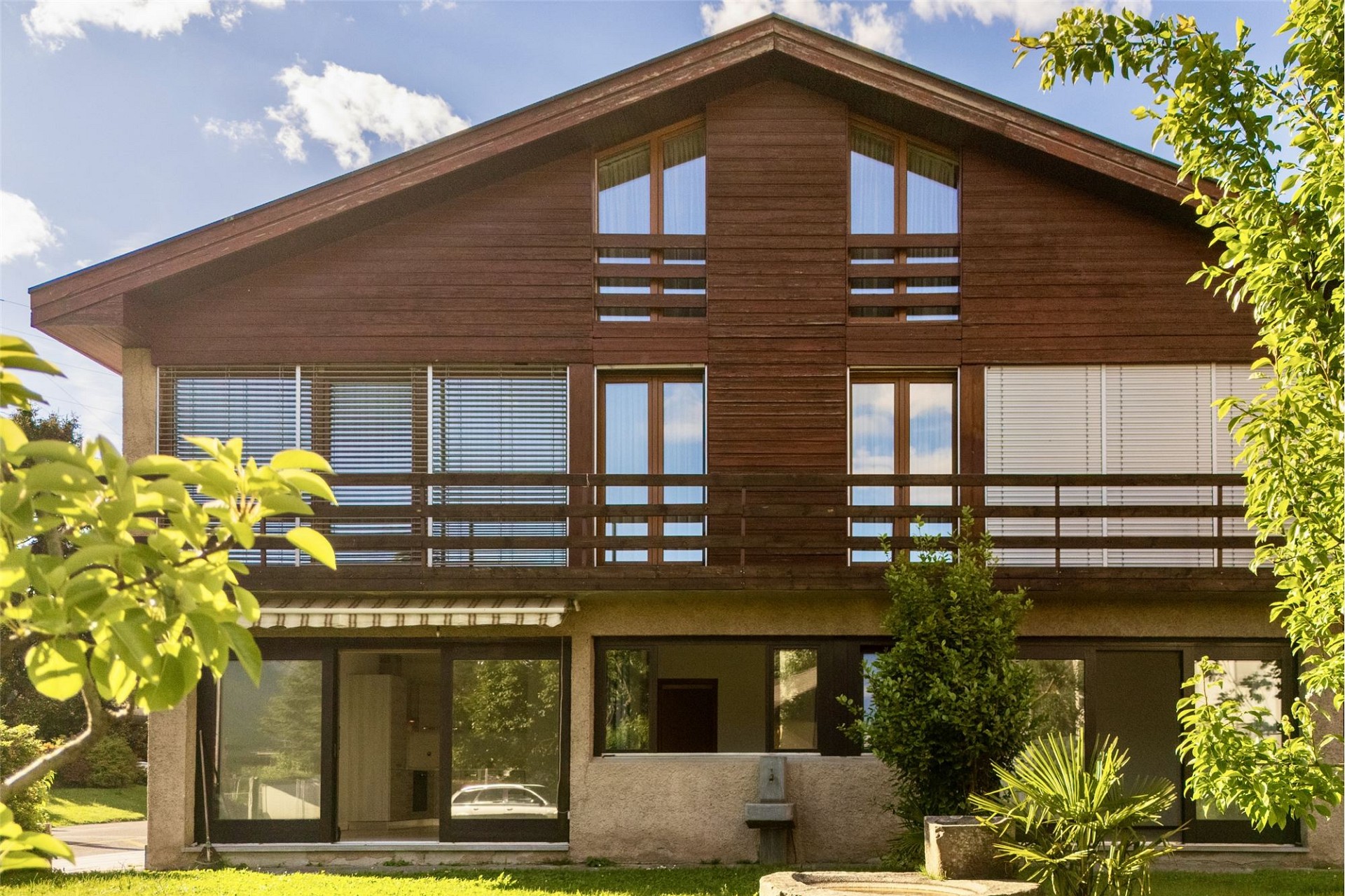 Zweistöckiges Haus mit Holzfassade und Satteldach