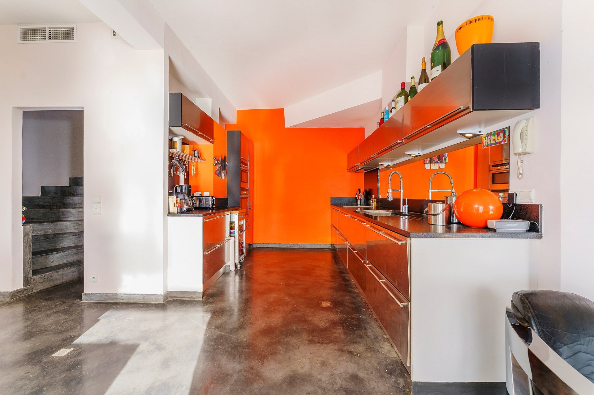 Moderne Küche mit auffälliger orangefarbener Rückwand