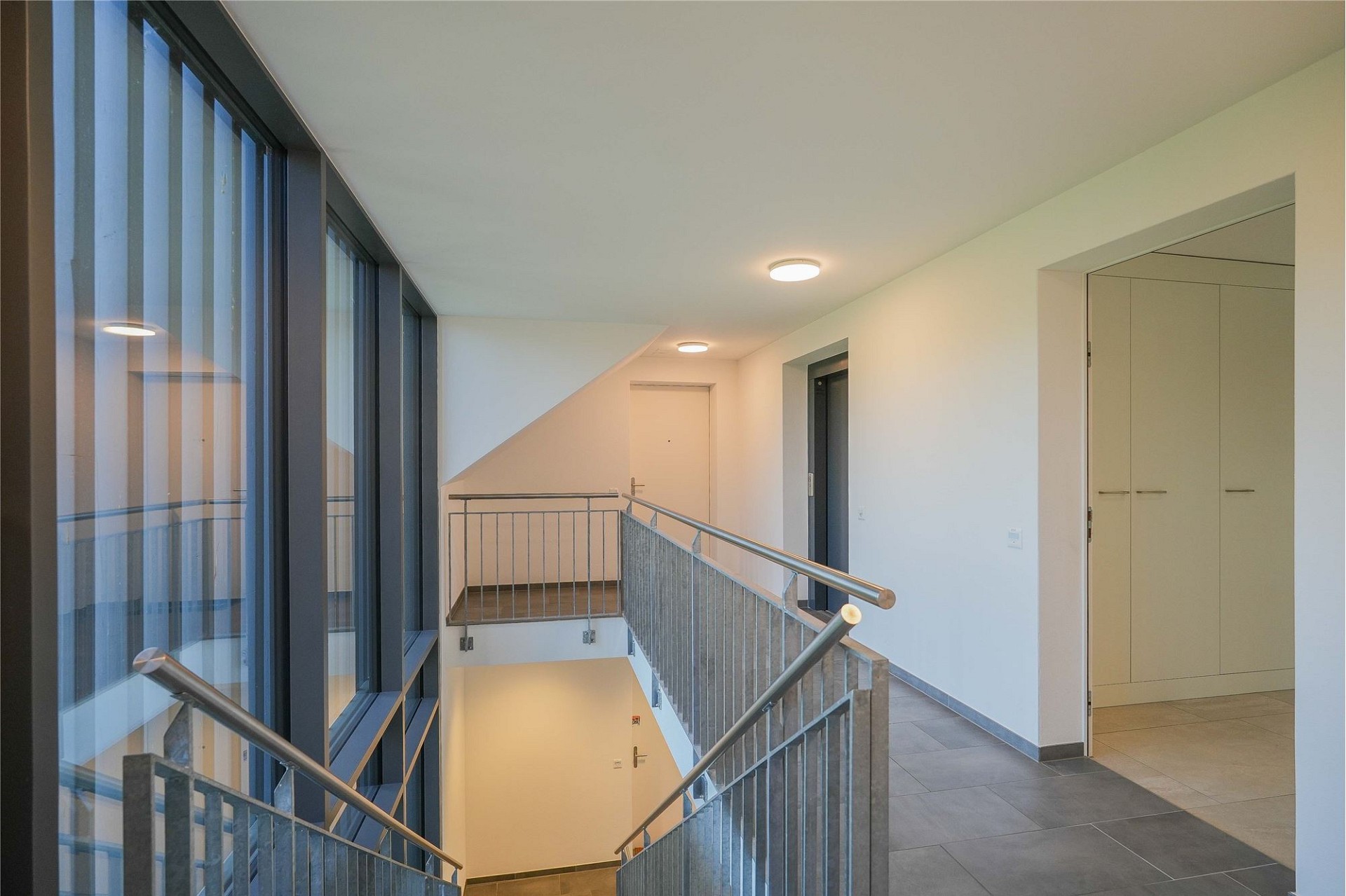 Treppenhausflur mit Glasfront und Türen