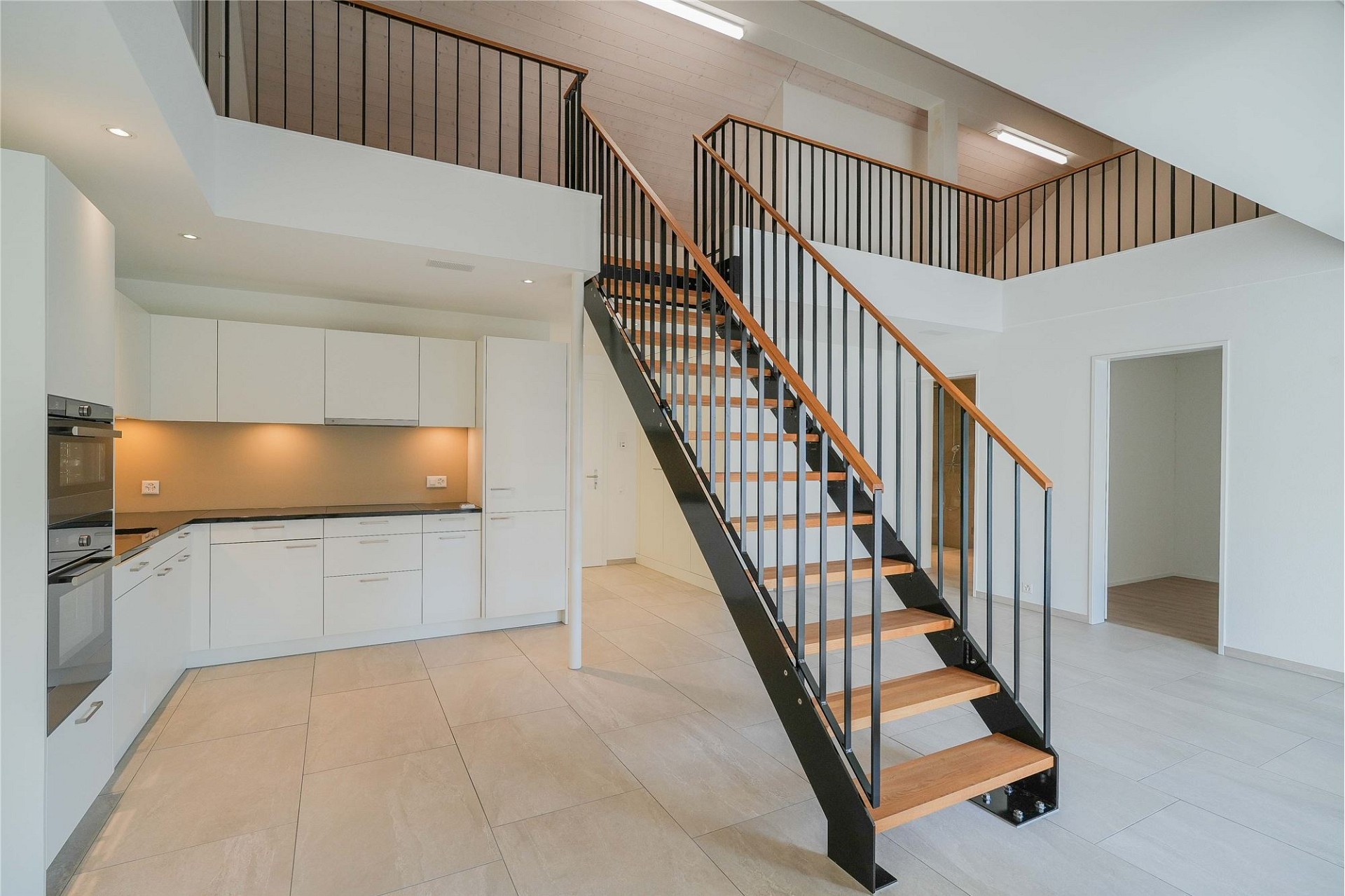 Moderne offene Küche mit Treppe und Galerie